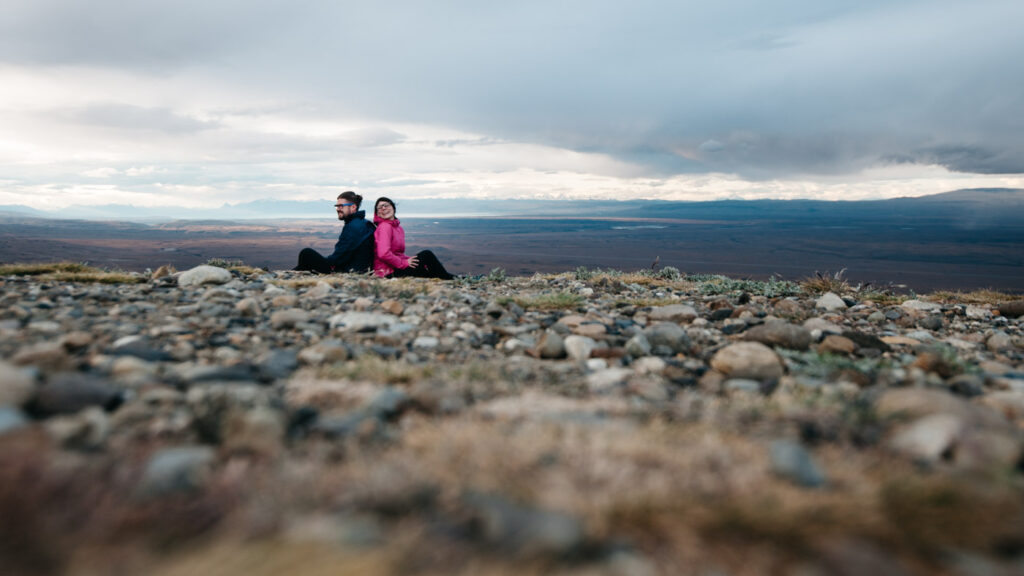 Bianca und Tom sitzen auf einem steinigen Aussichtspunkt in Patagonien