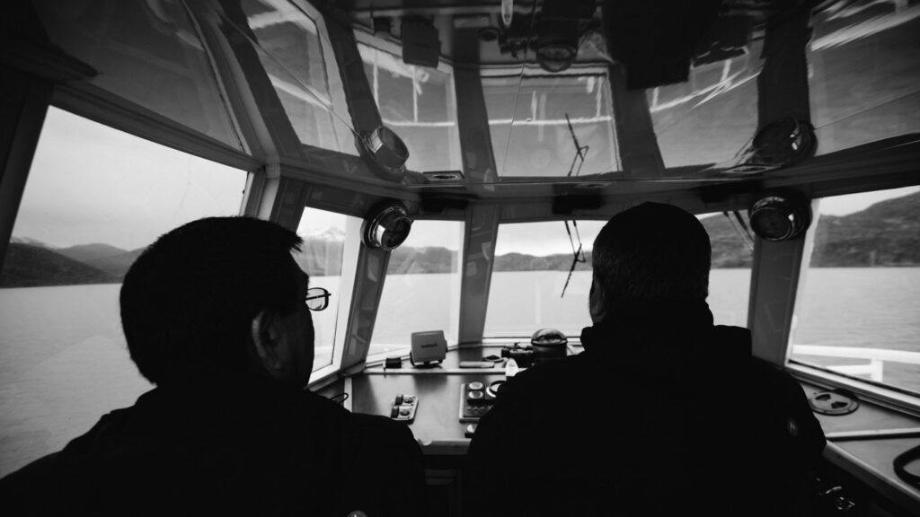 Kapitän und Begleiter im Steuerstand des Katamarans auf dem Lago Pehoé