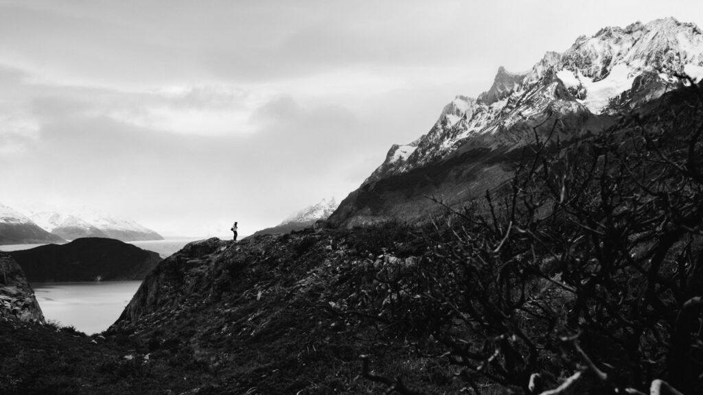 Wanderer über dem Lago Grey vor schneebedeckten Bergen