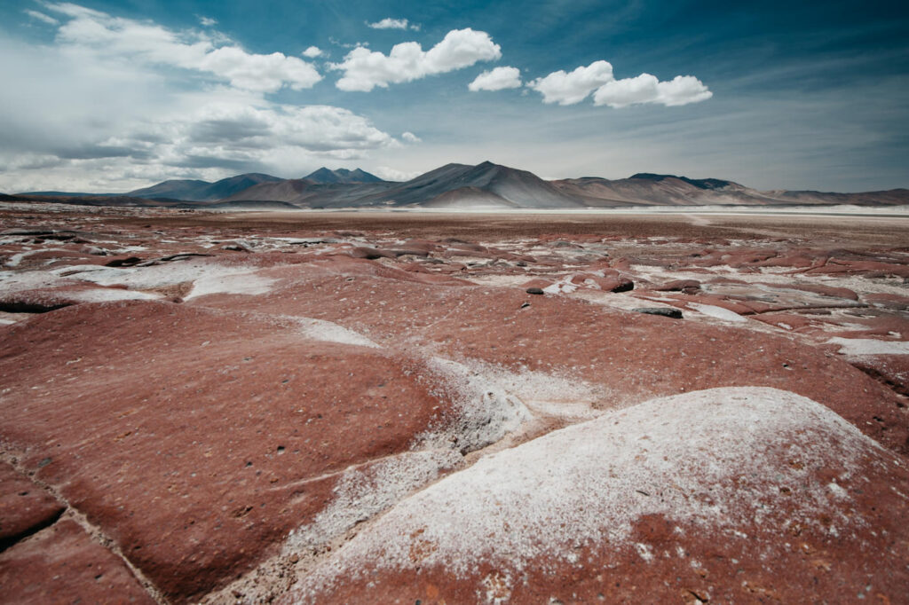Rote, salzüberzogene Felsen der Piedras Rojas vor Bergen