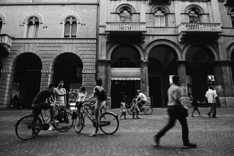 Radfahrer und Fußgänger vor Arkaden in Bologna