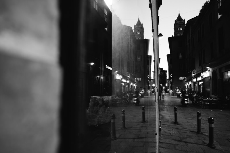Straße mit Kirchtürmen in Bologna bei Nacht