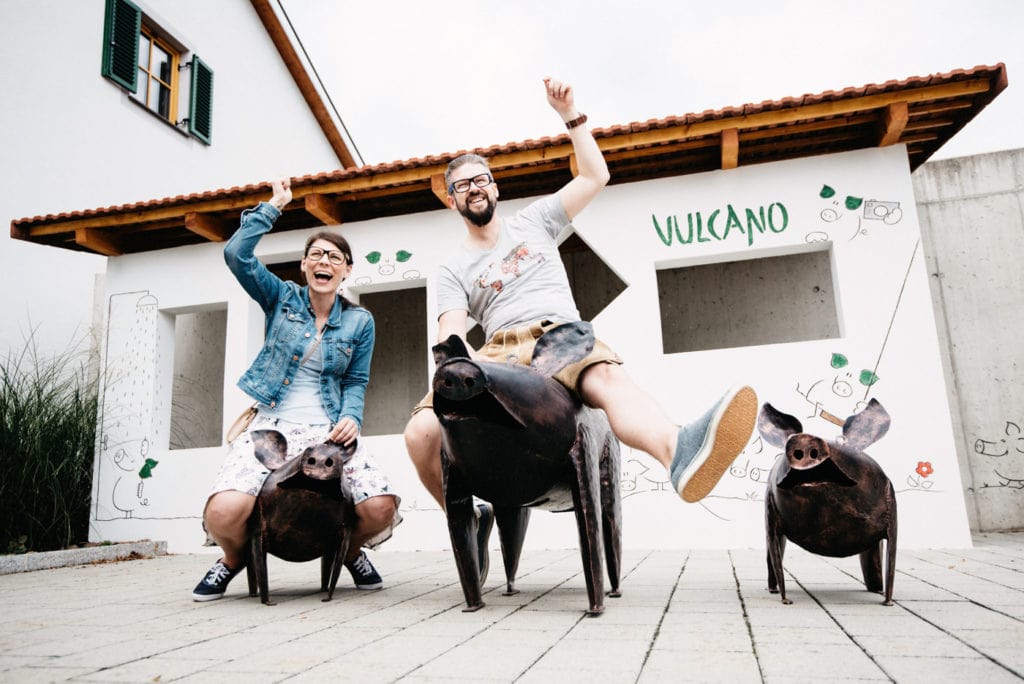 Riding metal pigs in front of the Vulkano ham factory in southern styria