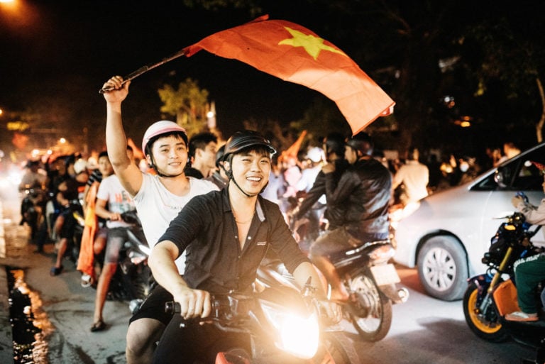 Ho Chi Minh City Guy riding on a scooter with vietnamese flag