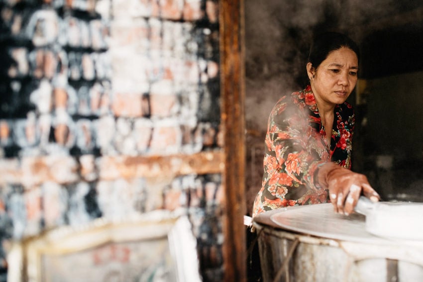Woman producing fine rice paper by hand