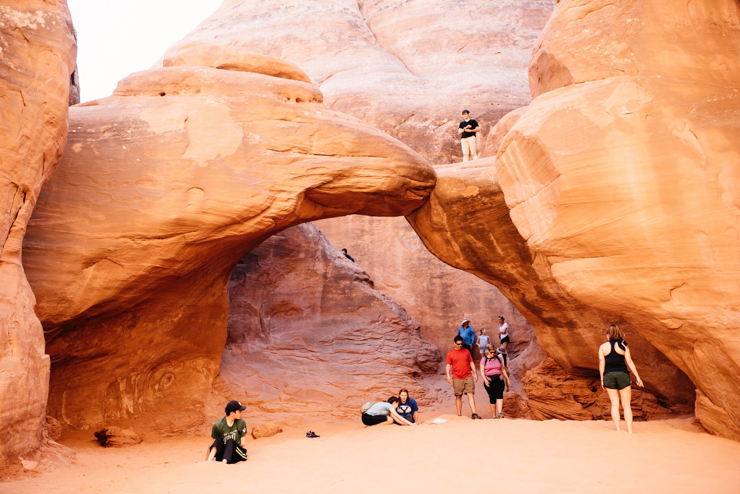 Visitors beneath the shaded Sand Dune Arch