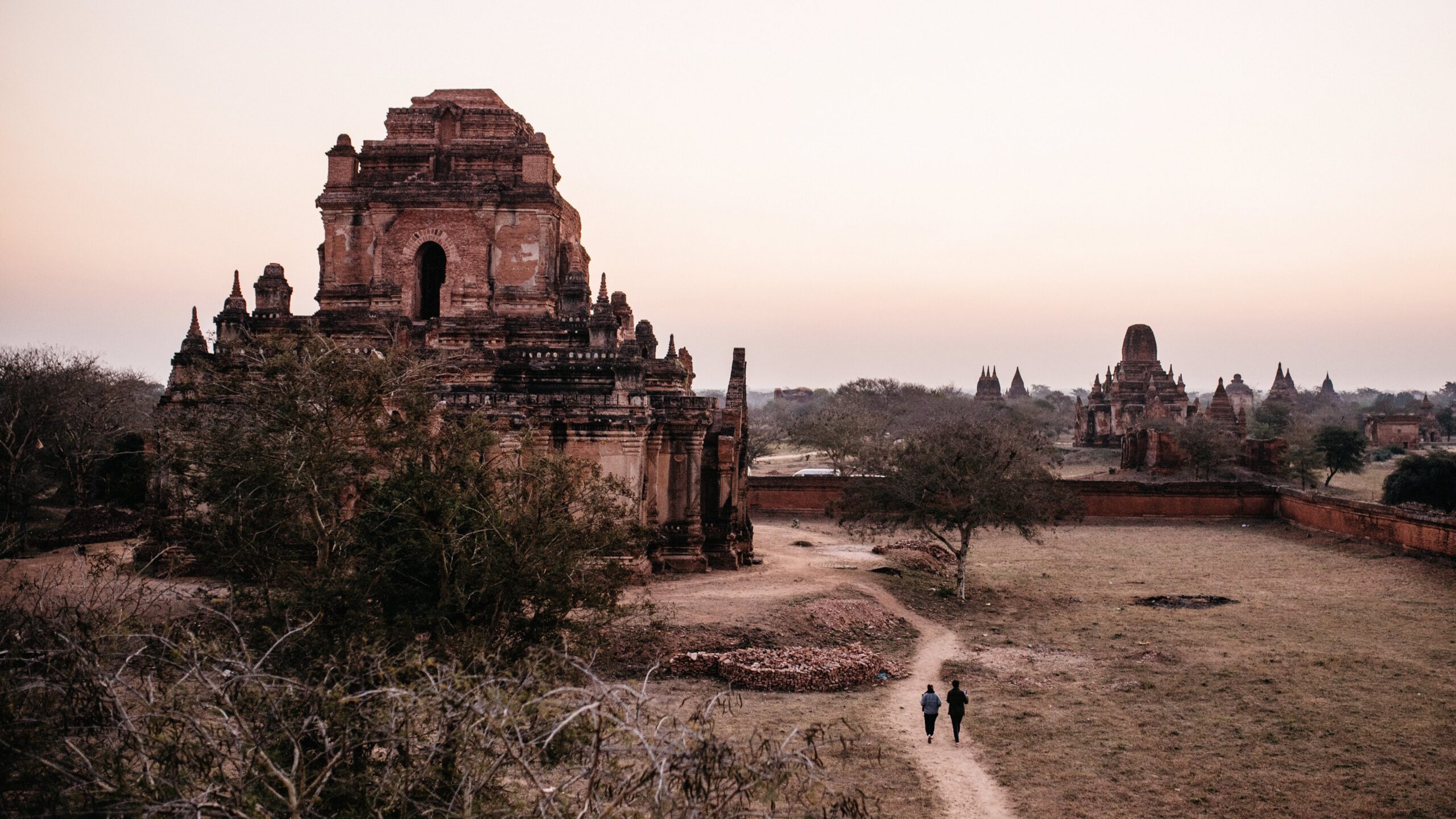 Visitors walking towards an ancient brick temple in Bagan