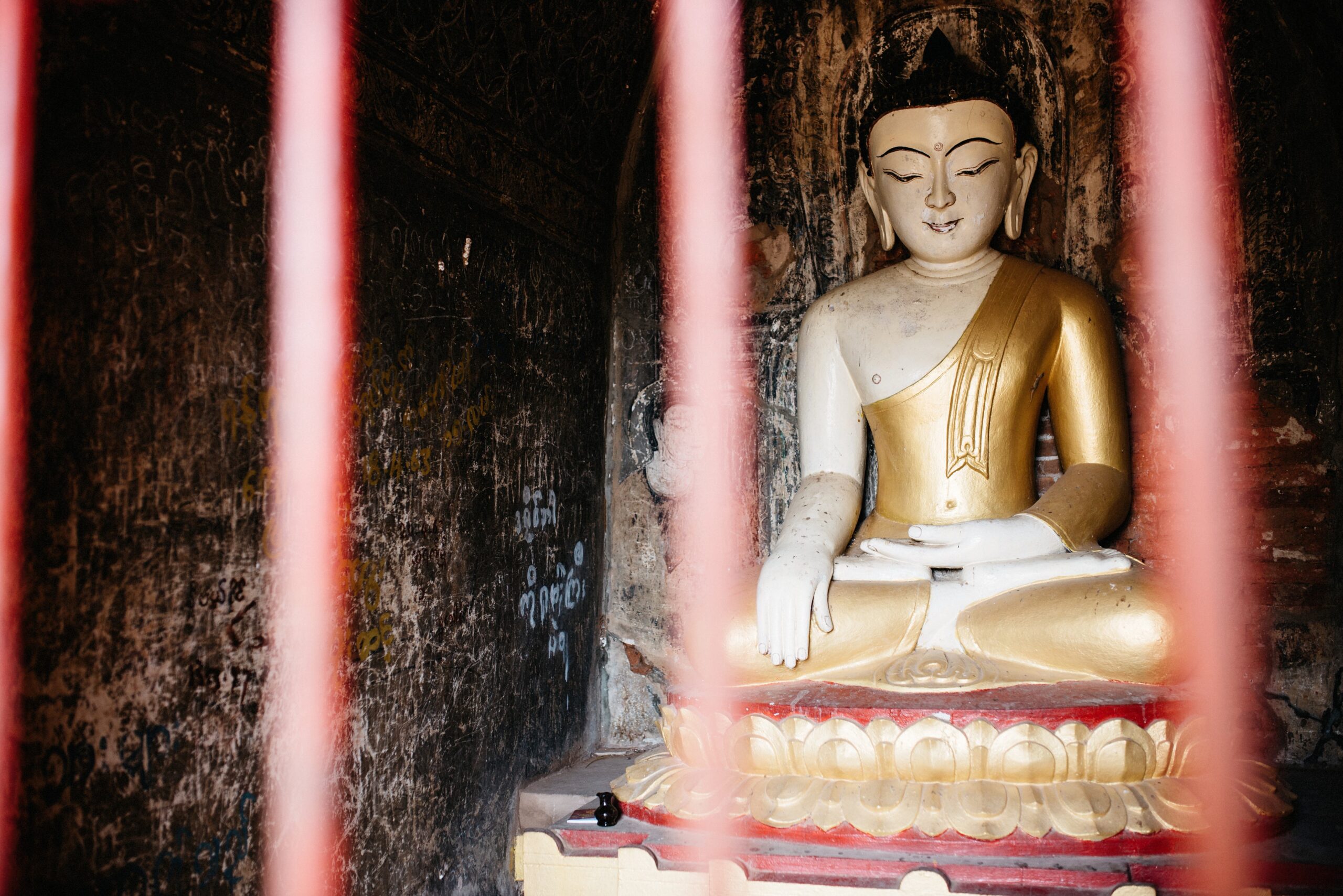 A seated Buddha statue inside a brick temple in Bagan