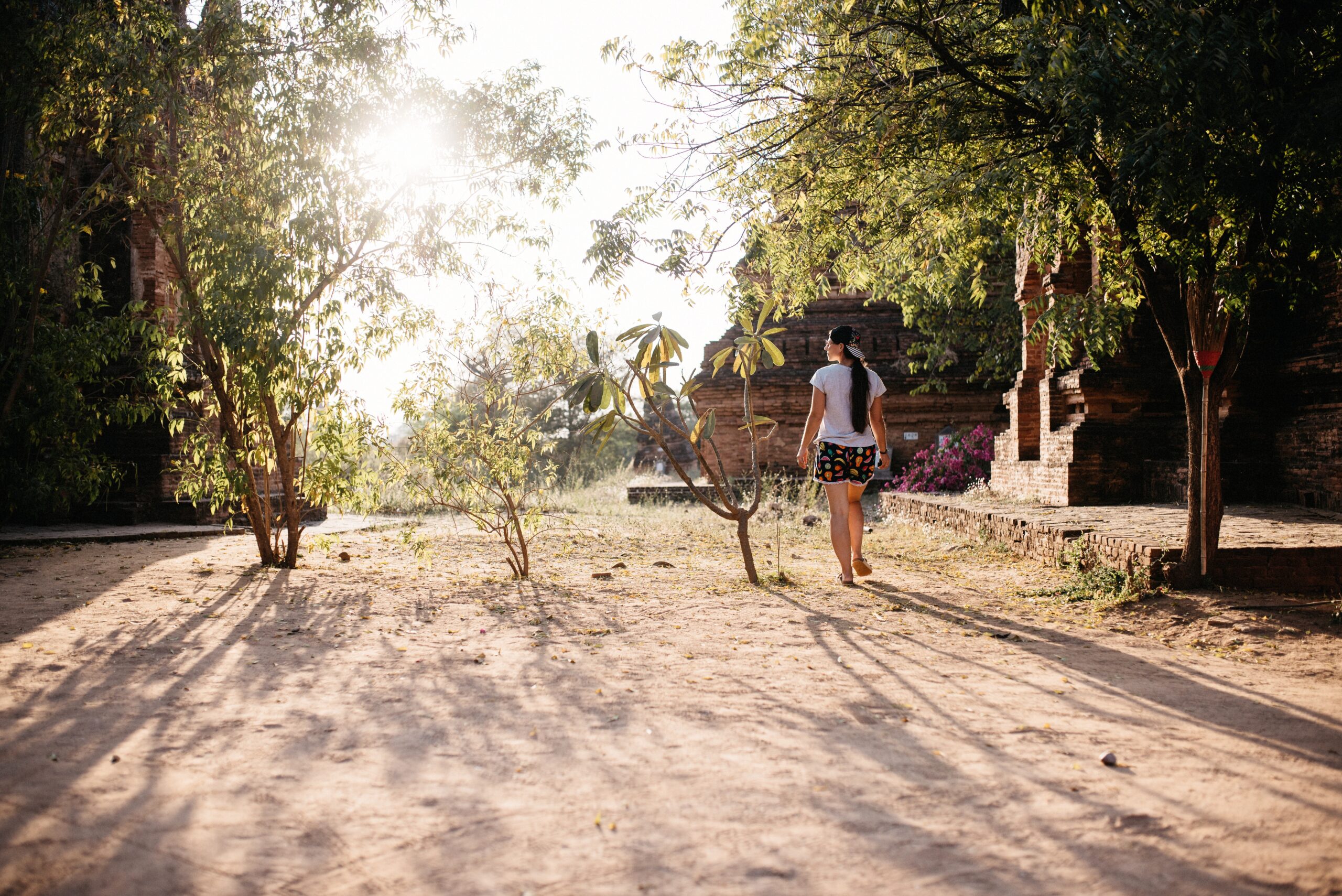 Bianca walking along a sandy path between temples in Bagan
