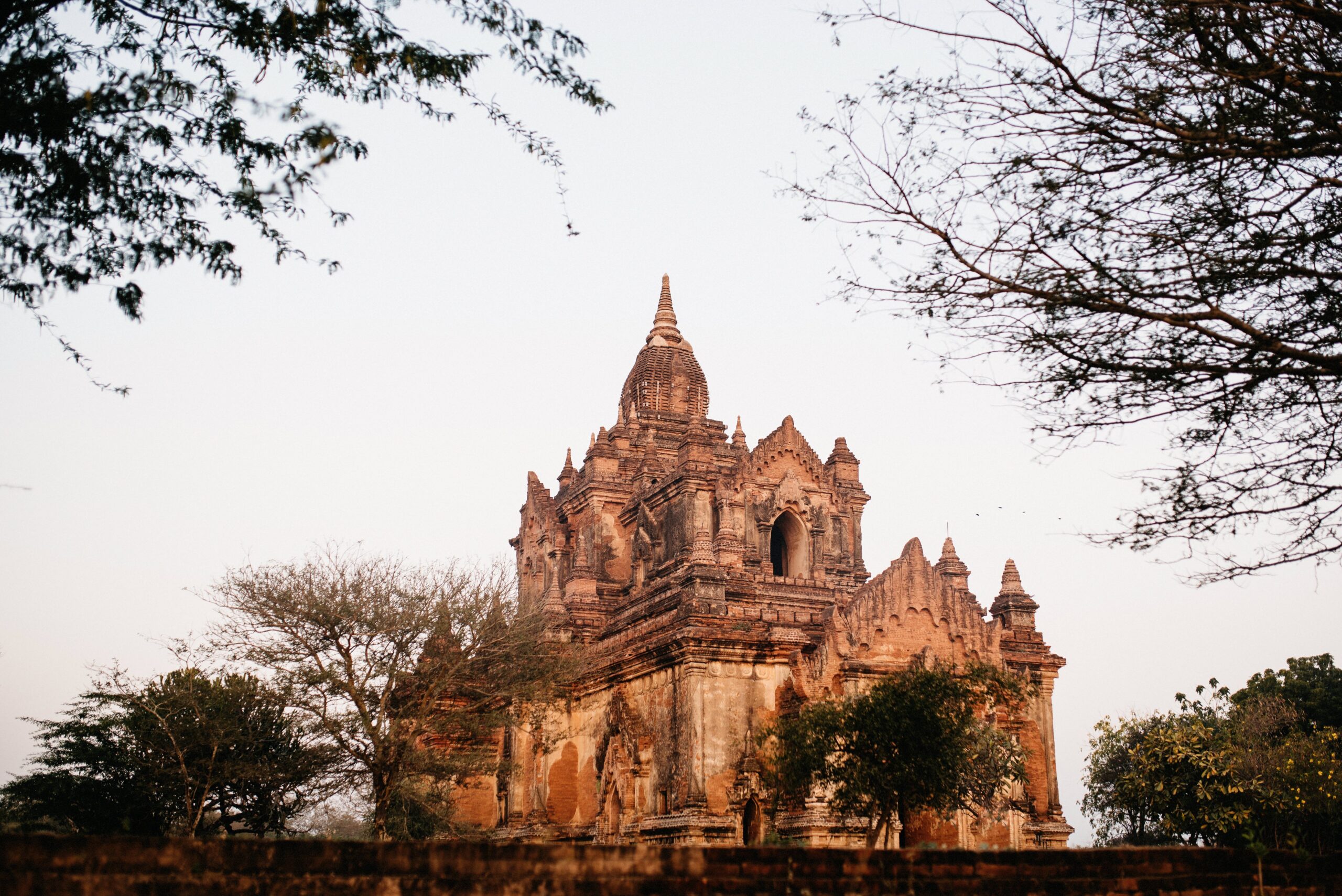 An ornate brick temple glowing in the early morning light in Bagan