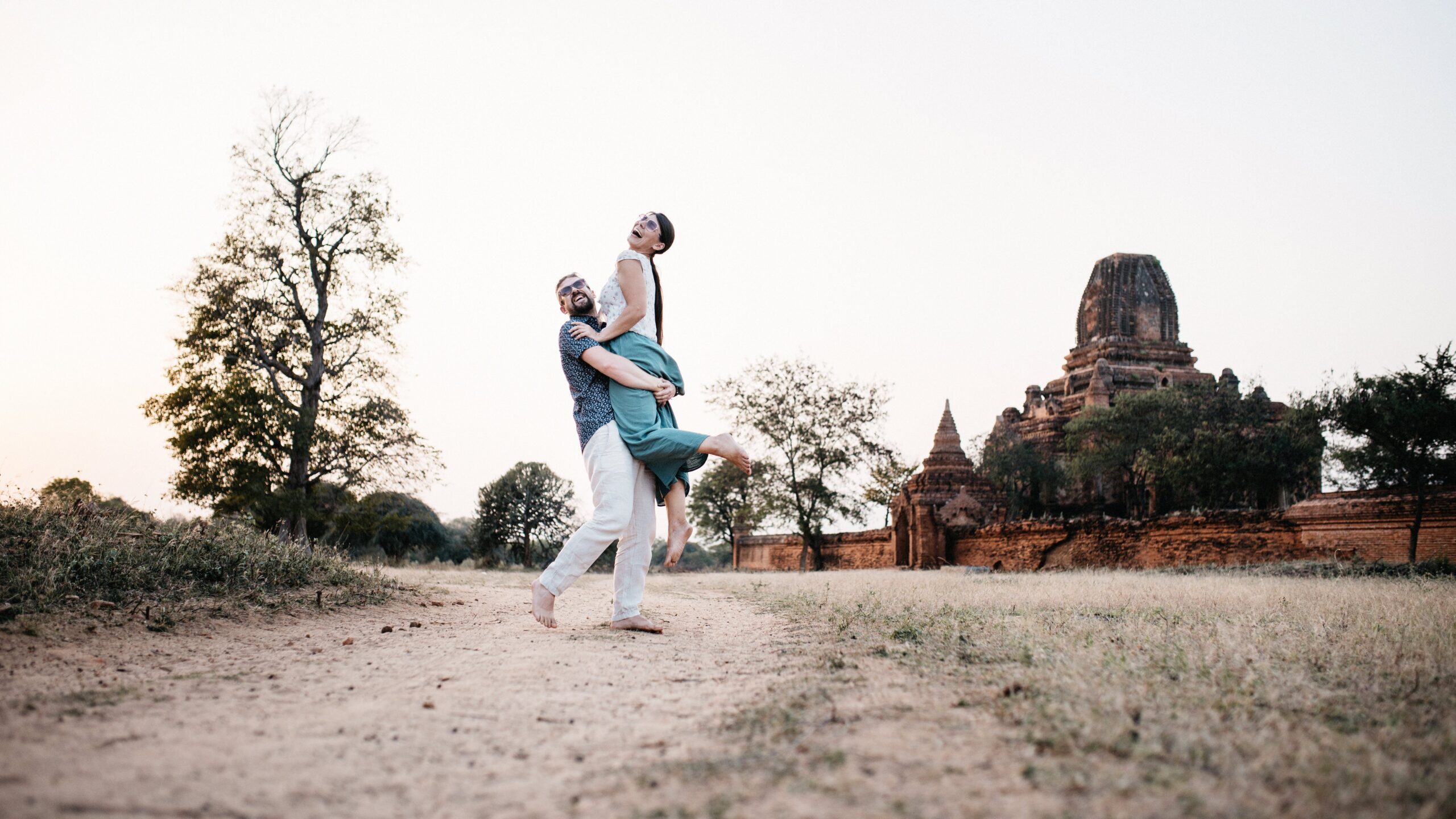 Tom lifting Bianca on a path beside an ancient temple in Bagan