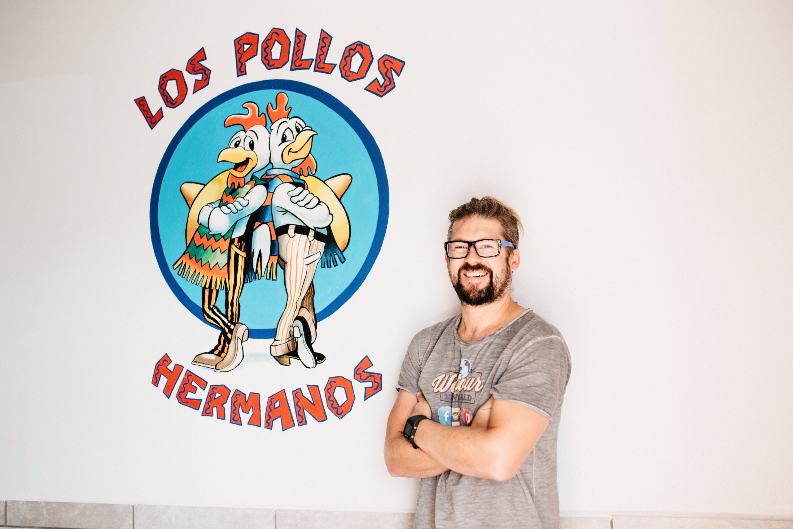 Tom beneath the Los Pollos Hermanos logo inside Twisters