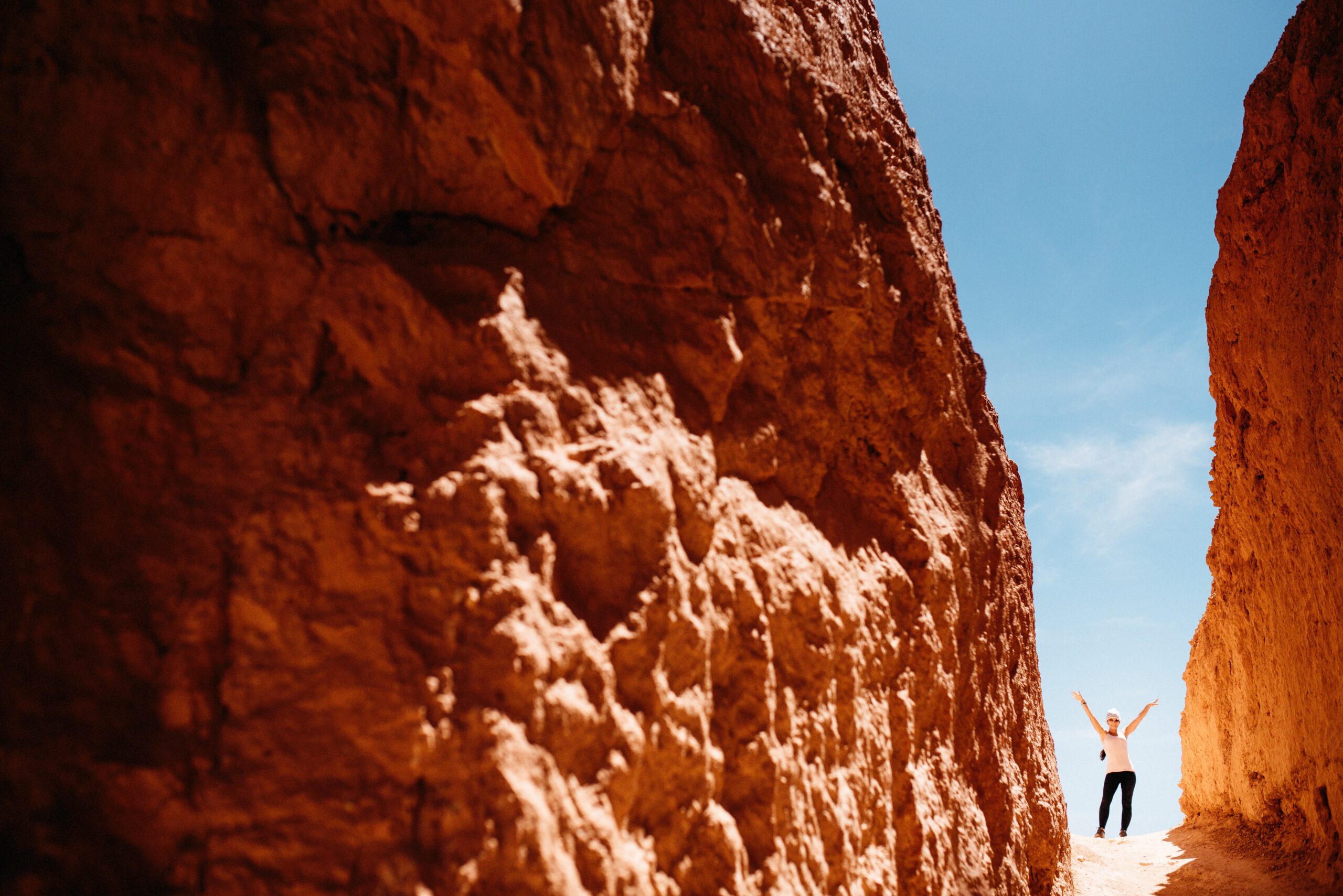 A hiker between the narrow red walls of the Navajo Loop