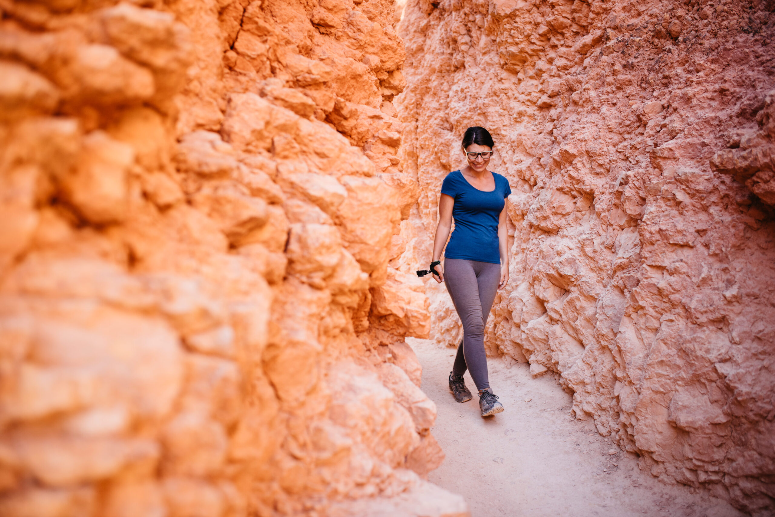 Bianca walking through a narrow orange section of trail