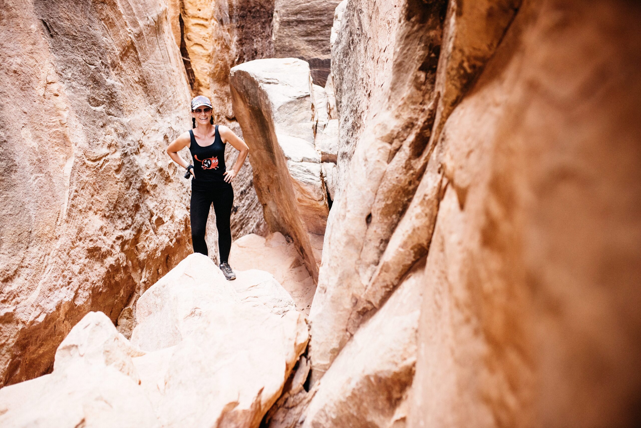 Bianca squeezing through a sandstone slot in the Needles