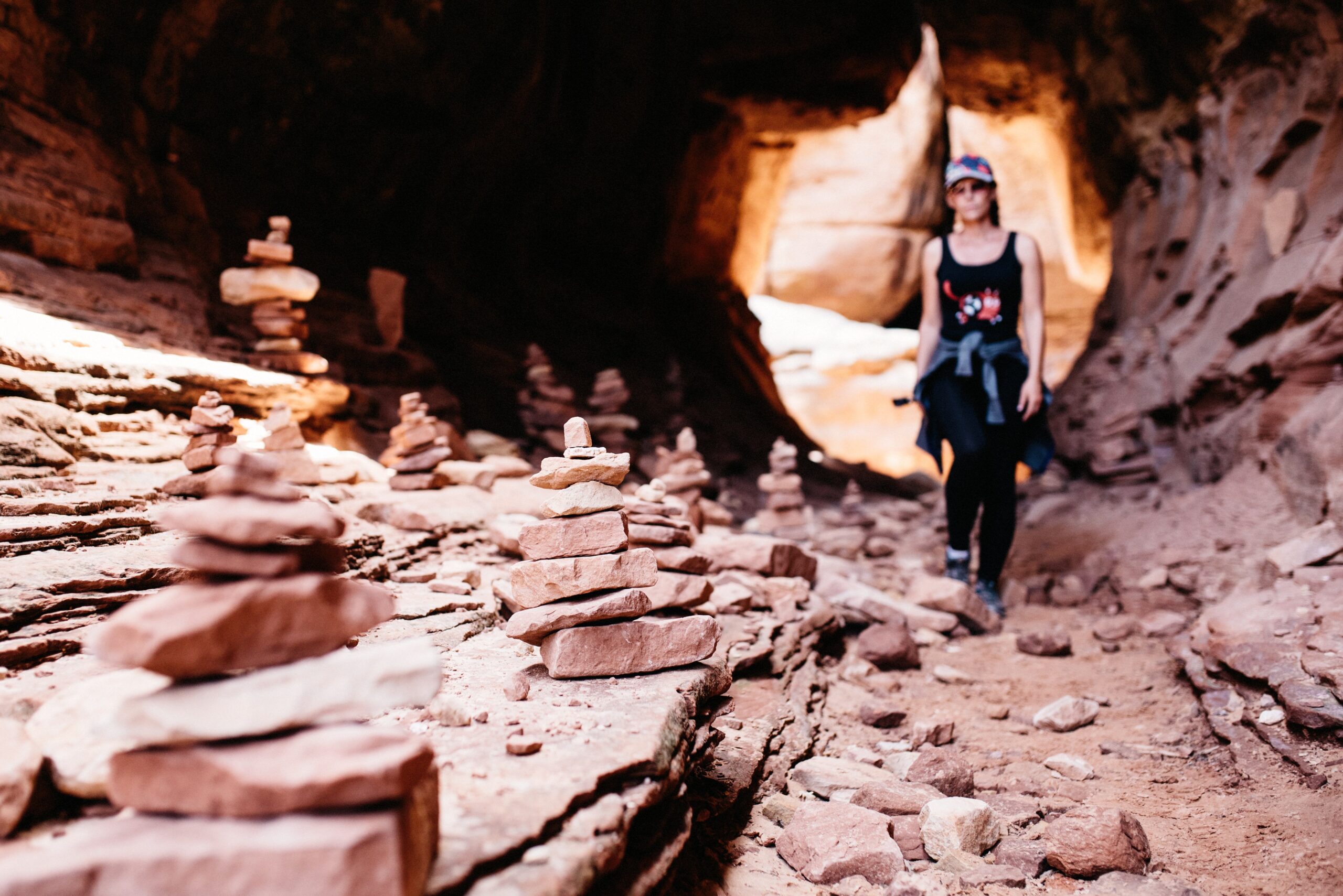 Bianca walking through warm reflected light inside a narrow canyon