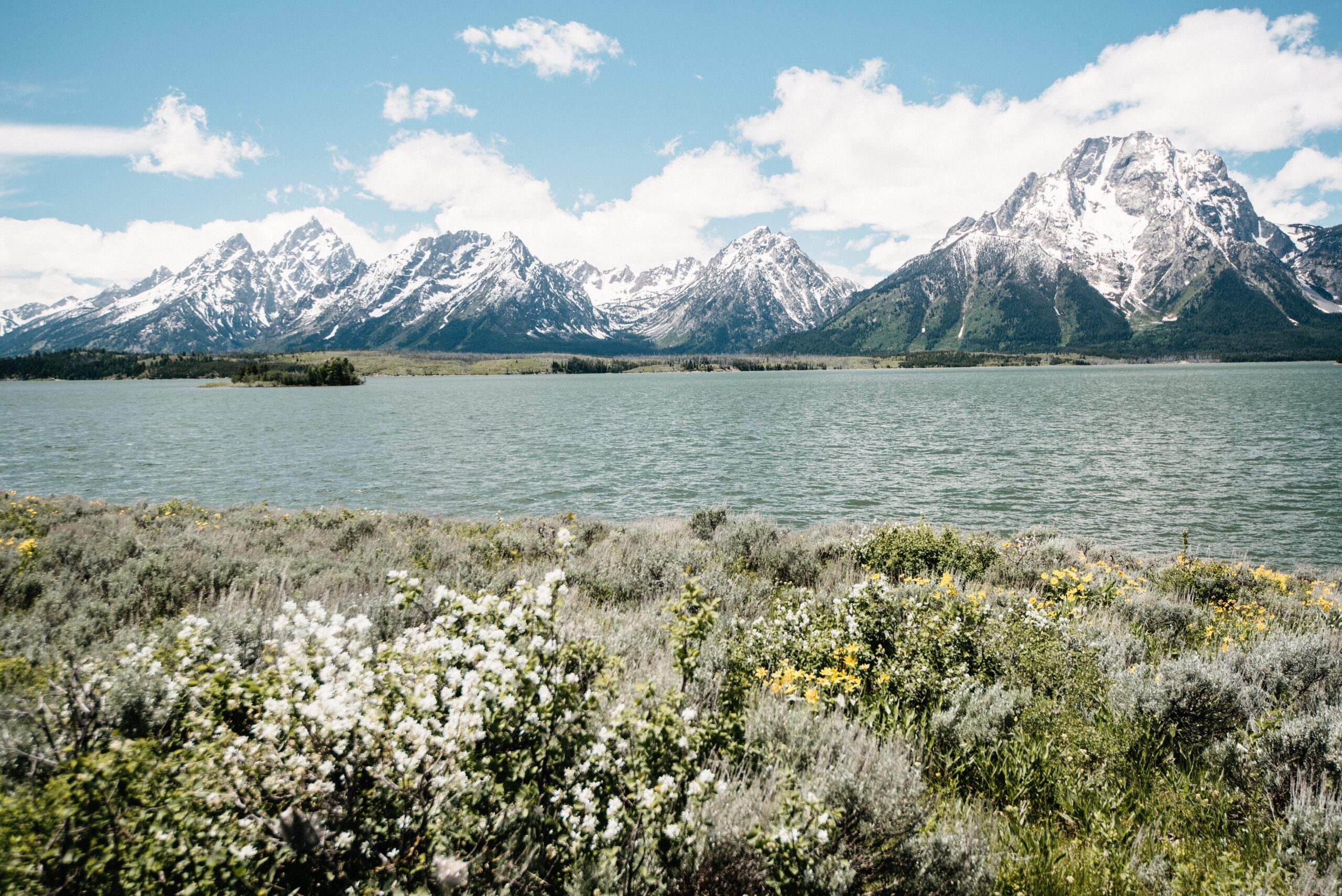 The snow-covered Teton Range rising behind Jackson Lake
