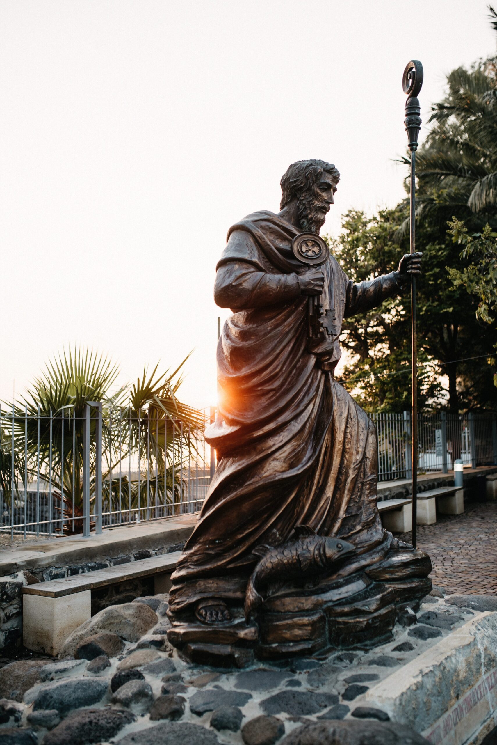A bronze statue of Saint Peter holding the keys beside the Sea of Galilee