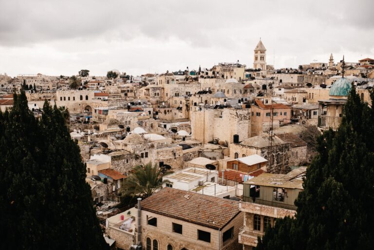 Die Kalksteindächer und Kirchtürme der Jerusalemer Altstadt unter grauem Himmel