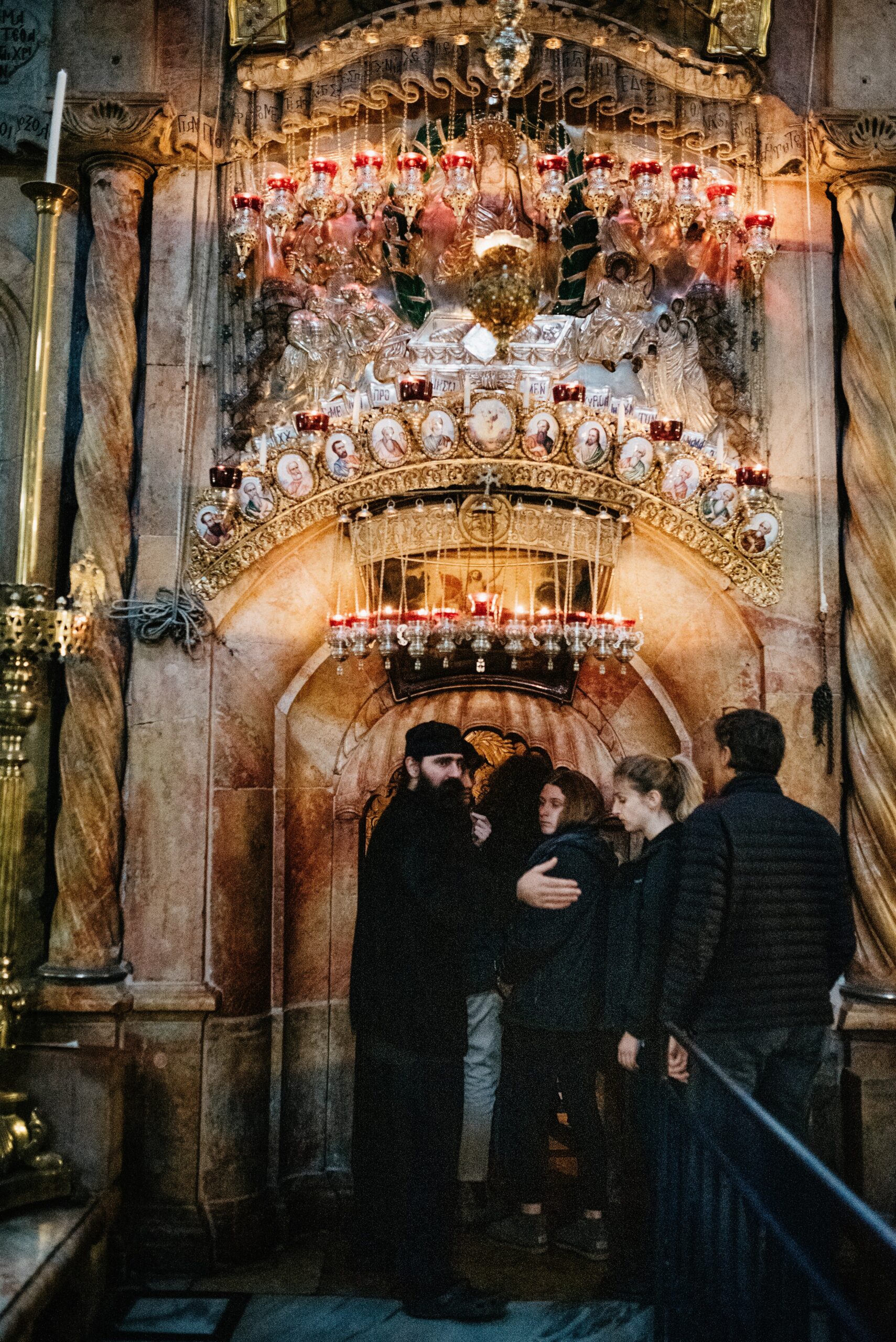 Pilgrims beneath ornate lamps inside the Church of the Holy Sepulchre