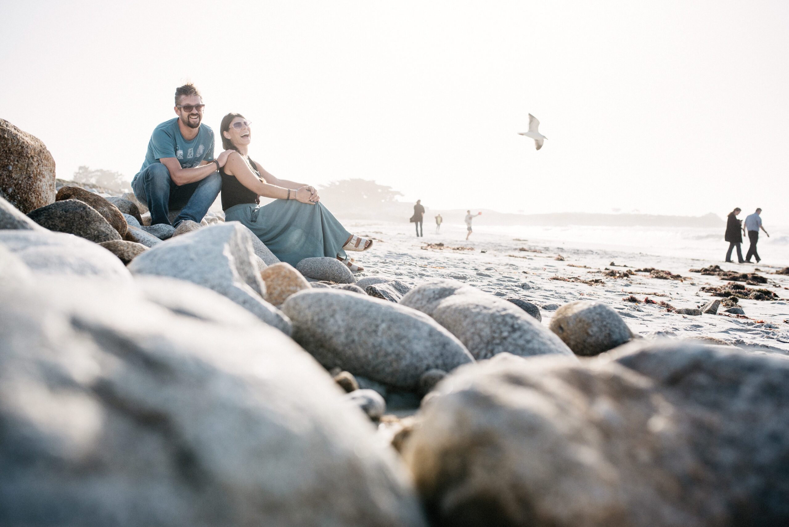 Bianca and Tom sitting together on the rocky California coast