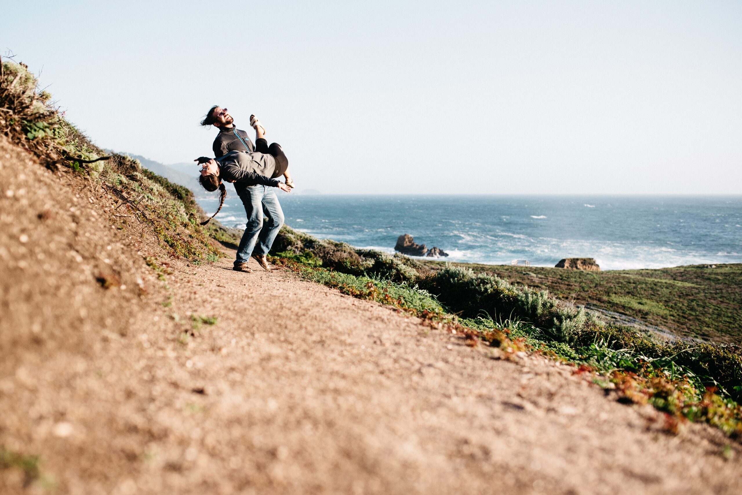 Bianca and Tom climbing a coastal path beside Highway 1