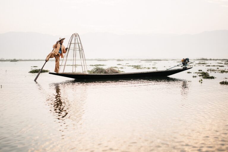 An Intha fisherman balancing on one leg at sunrise on Inle Lake