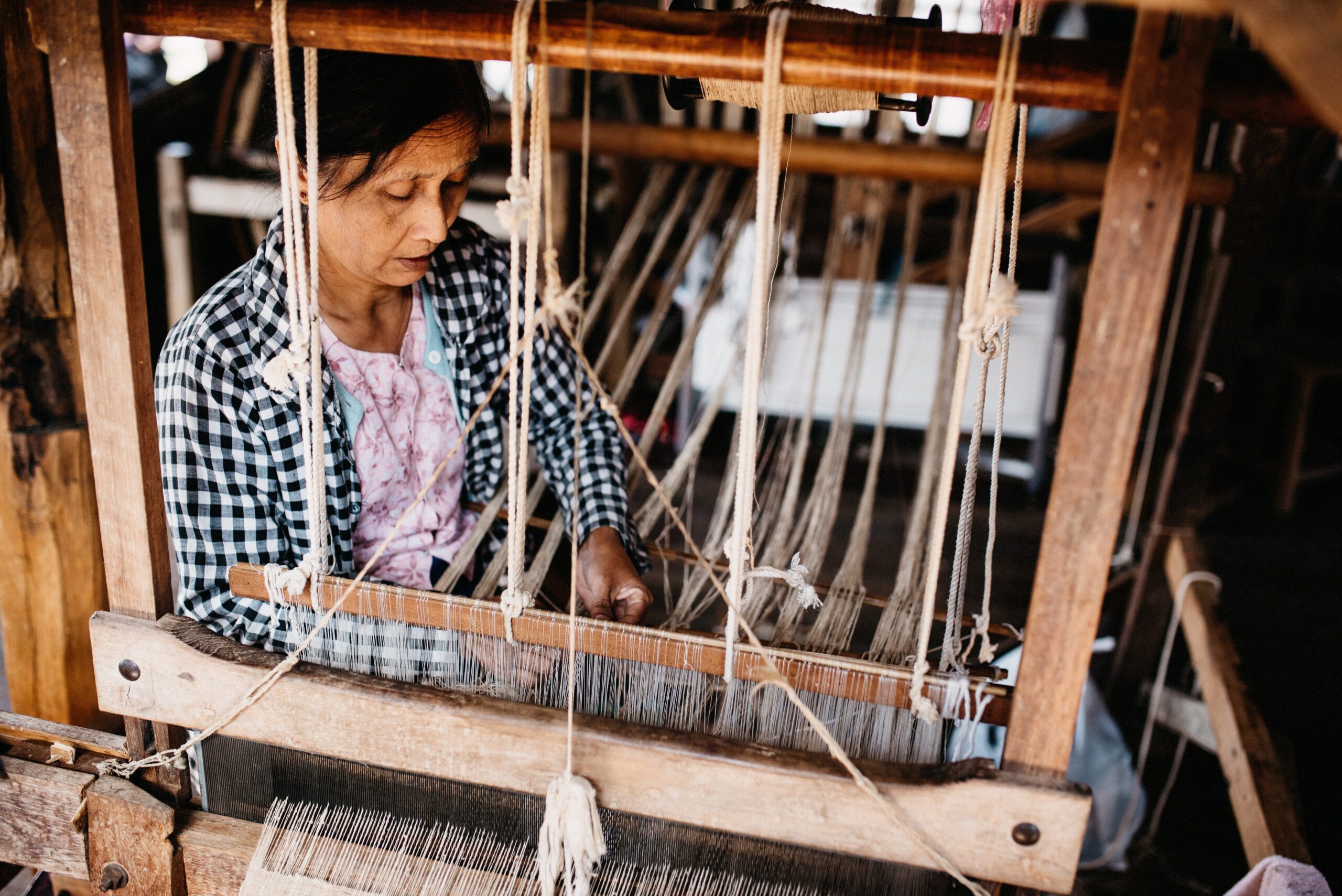 A woman operating a traditional loom at a lotus-weaving workshop