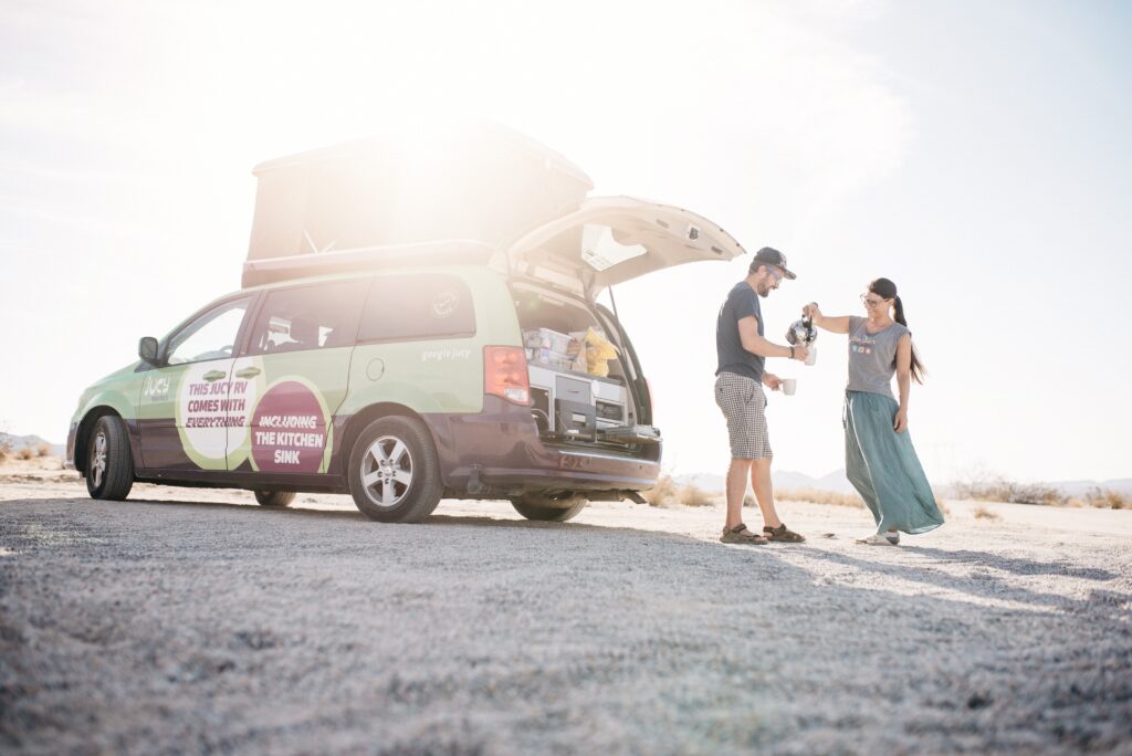 Bianca and Tom beside their campervan in the desert at Joshua Tree National Park