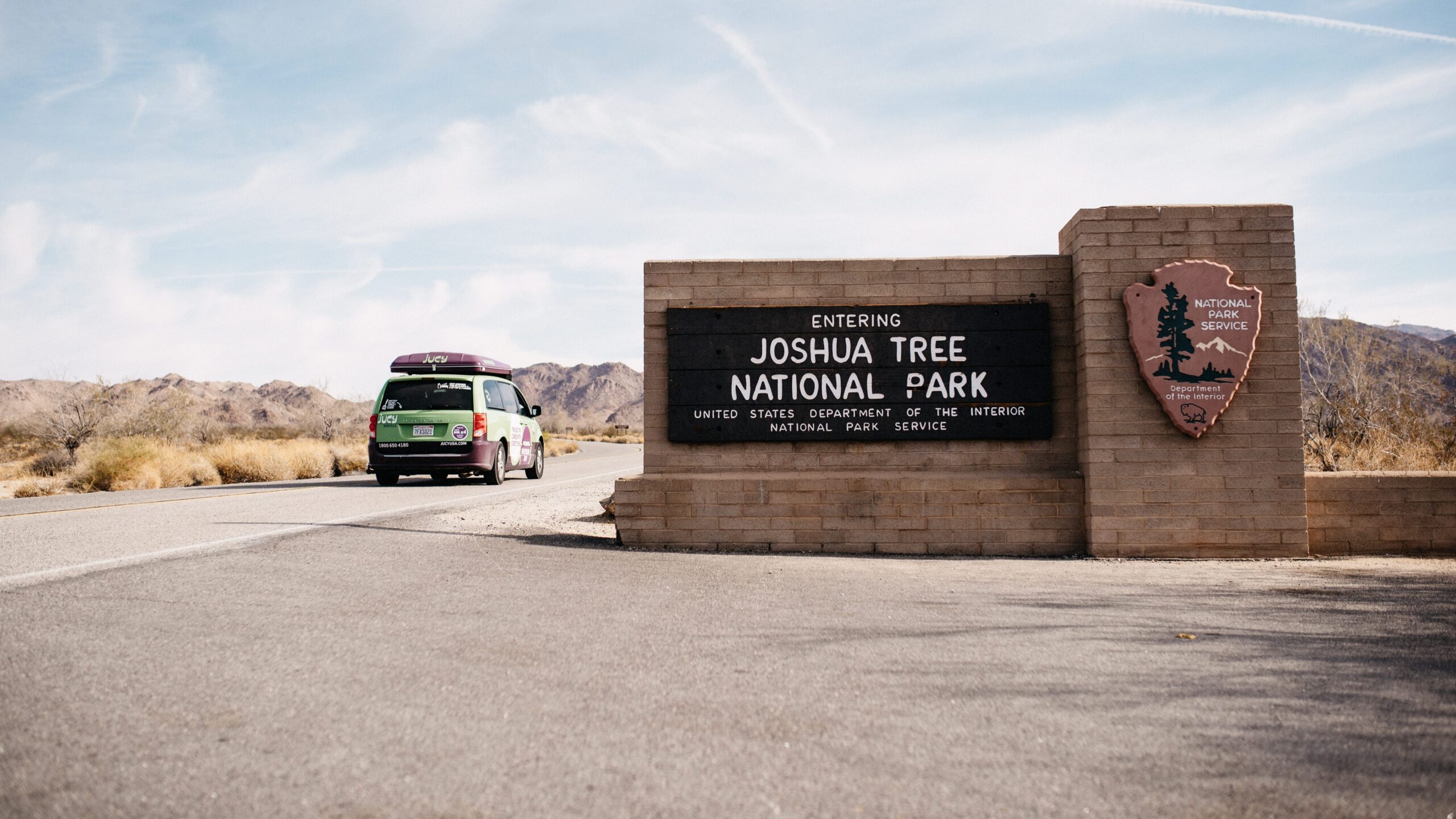 Unser JUCY Campervan neben dem Eingangsschild des Joshua Tree Nationalparks