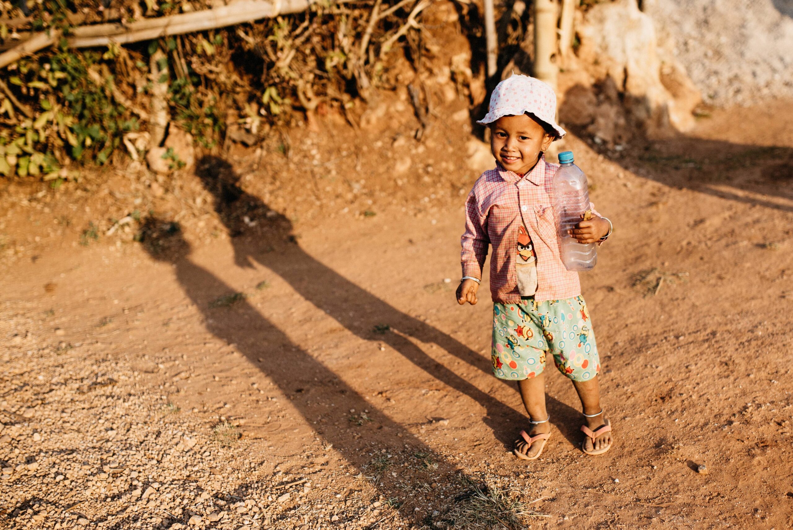 A child standing in the evening light of a rural village