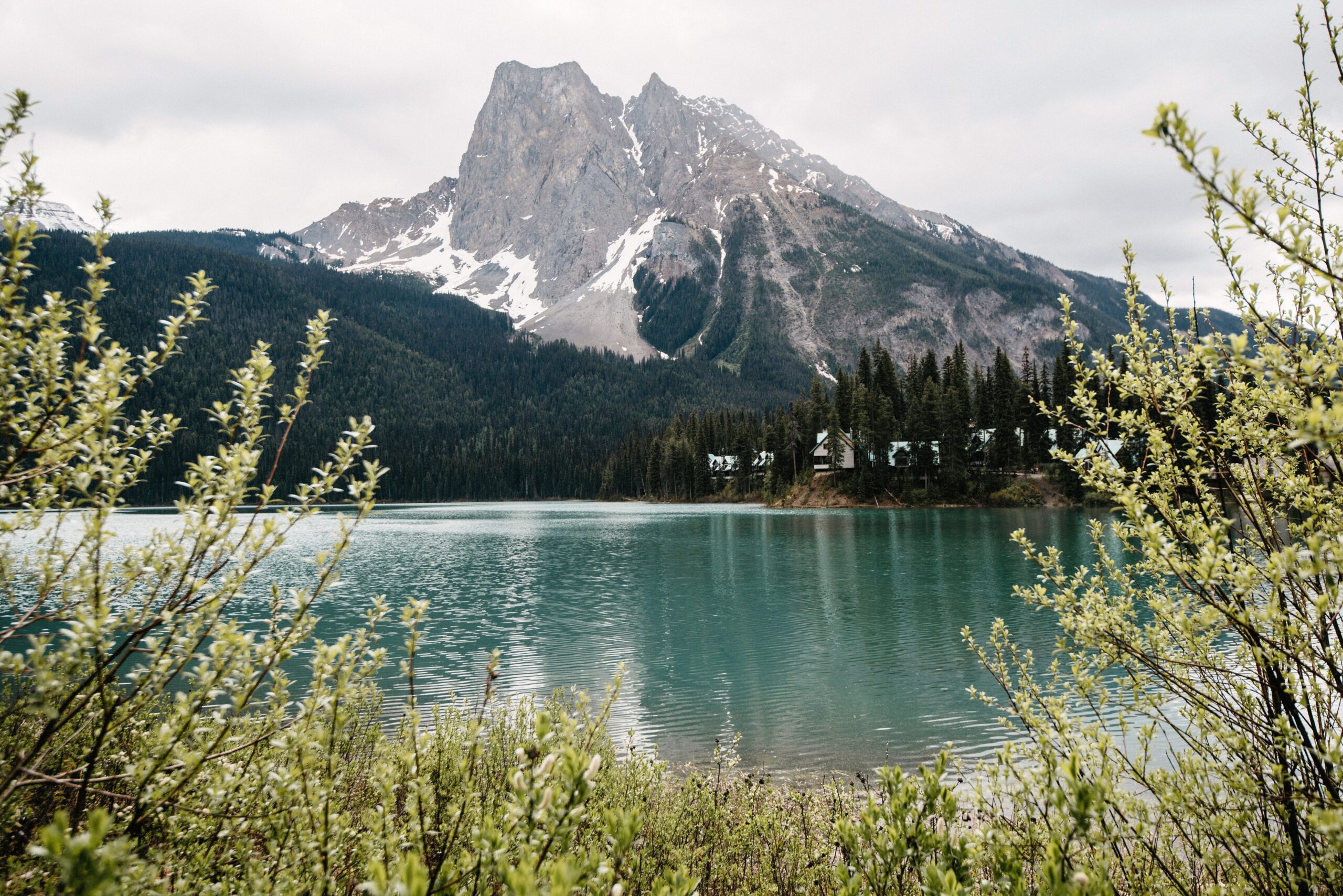 A turquoise lake and mountain range beside the road towards Banff