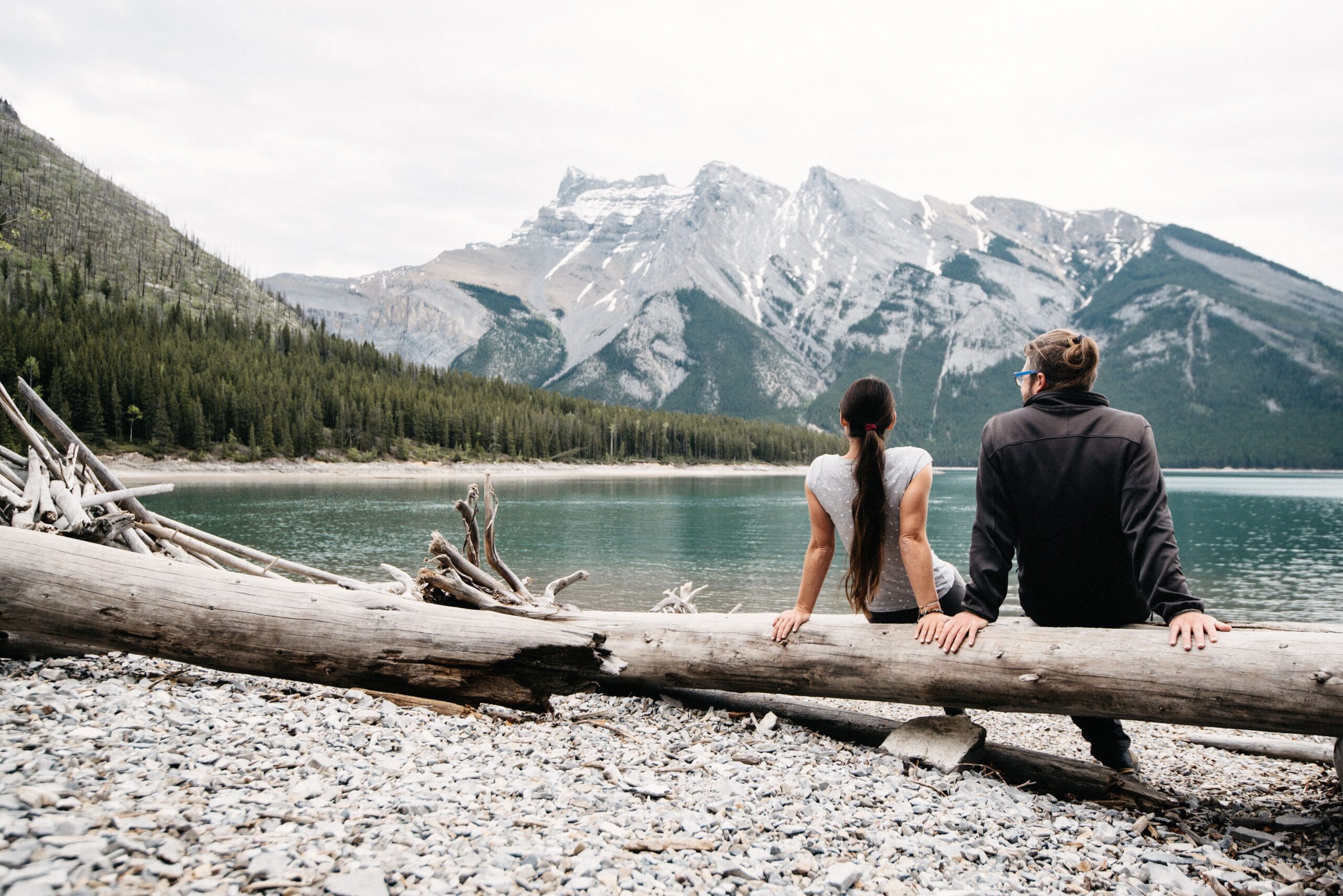 Bianca and Tom sitting beside a mountain lake near Banff