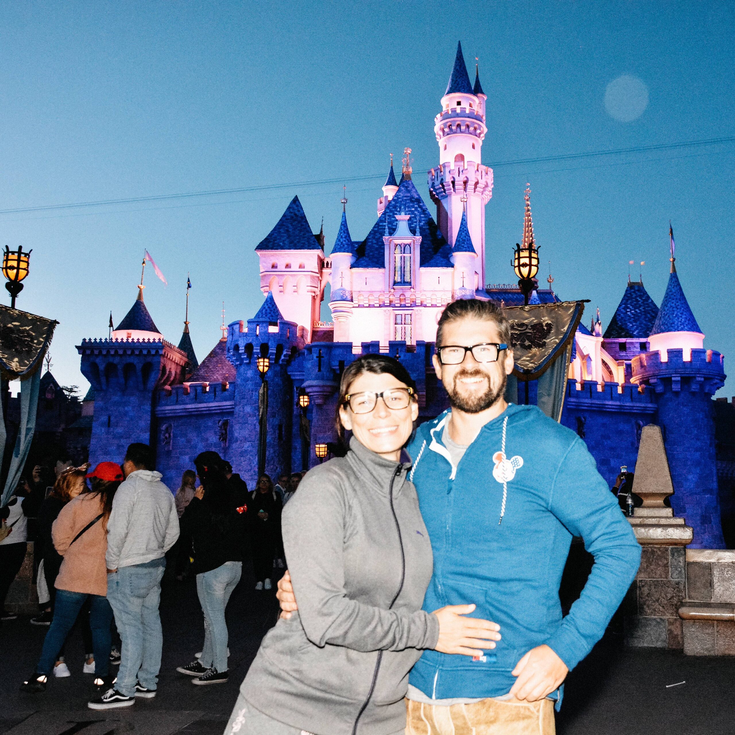 Bianca and Tom in front of the illuminated Disneyland castle