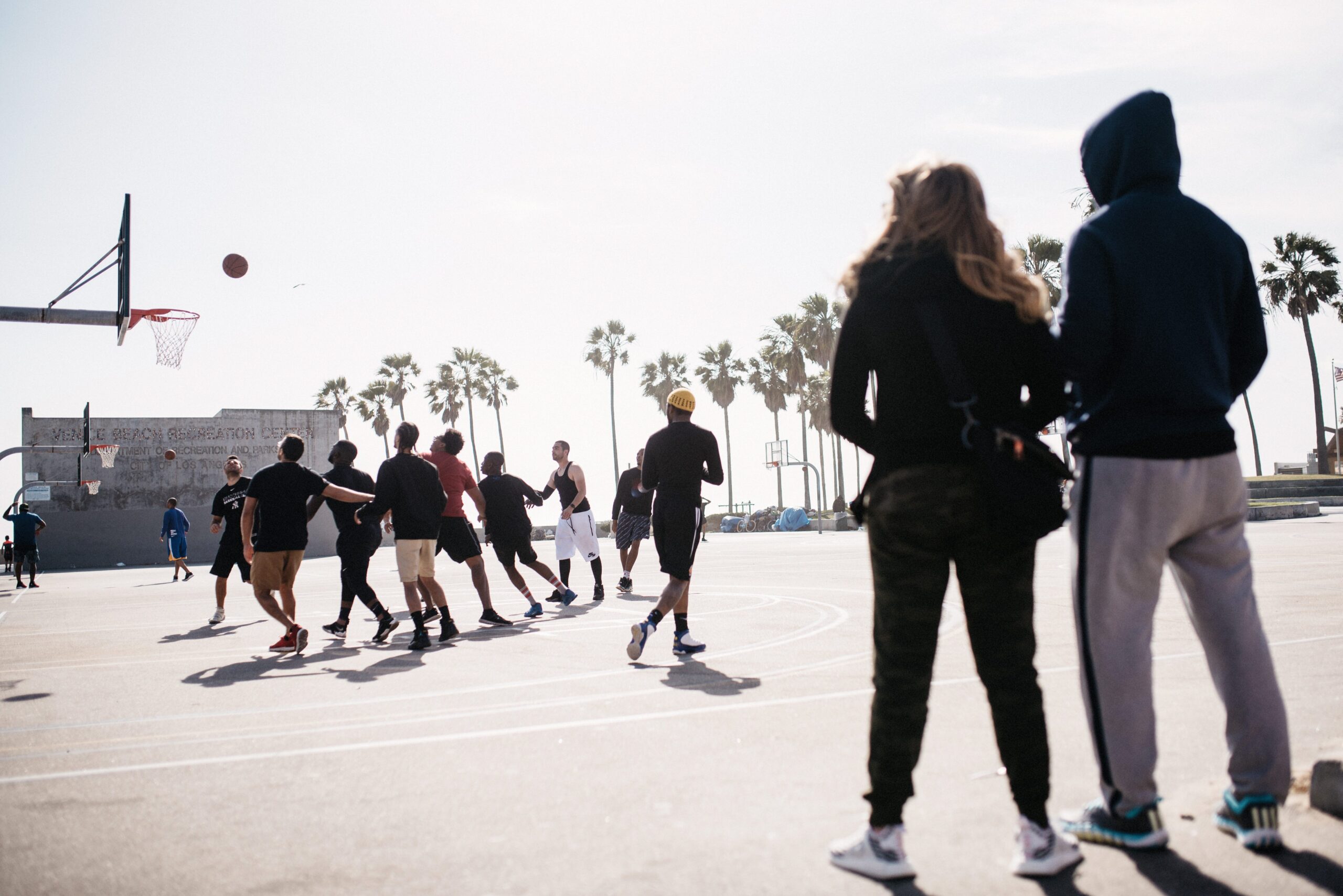 A basketball game beside Venice Beach
