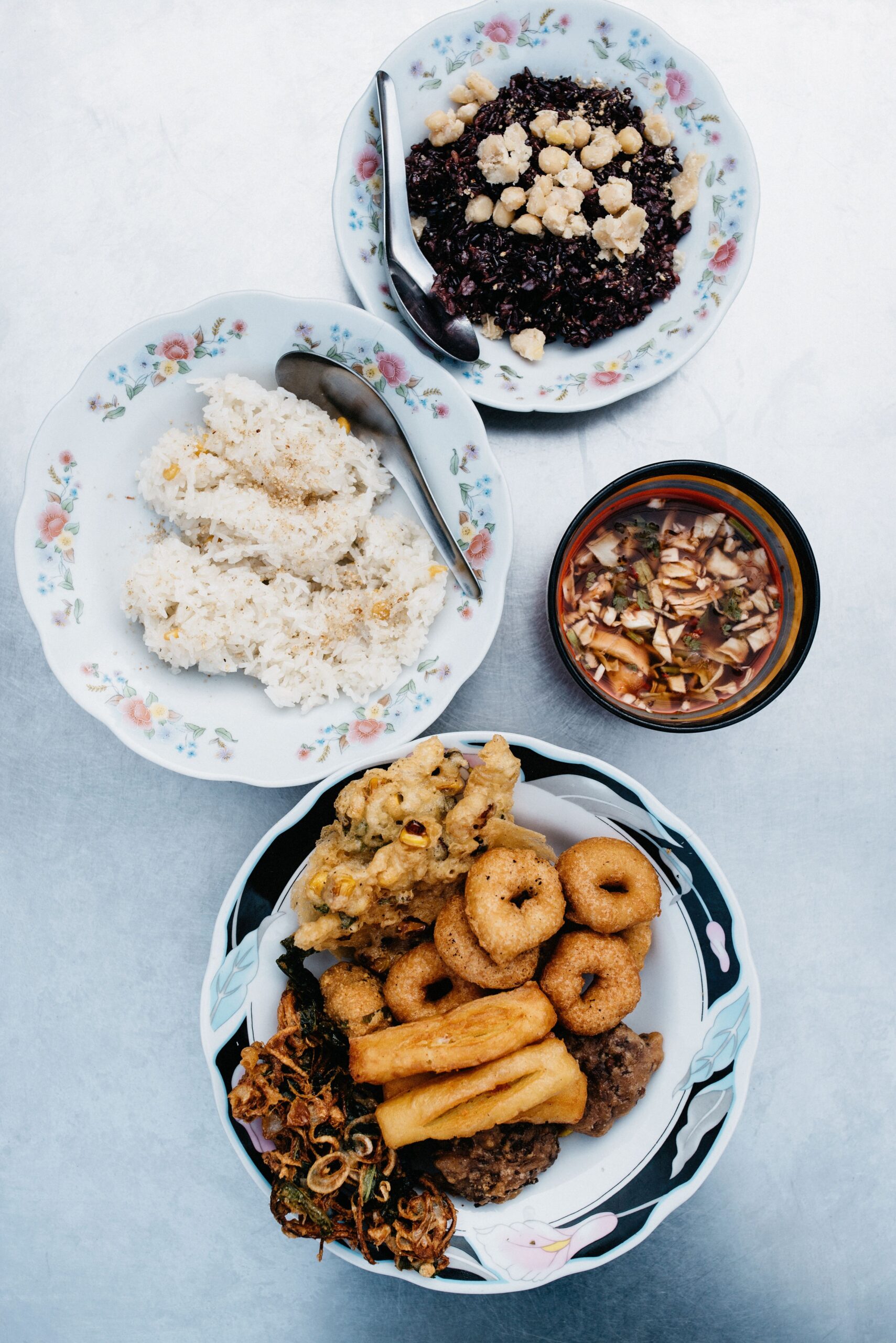 A Burmese breakfast spread with sticky rice and fried snacks