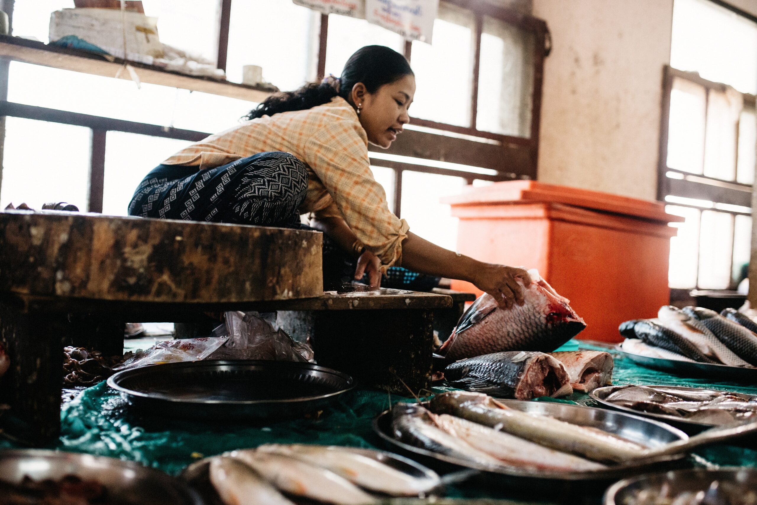 A market vendor preparing fresh fish