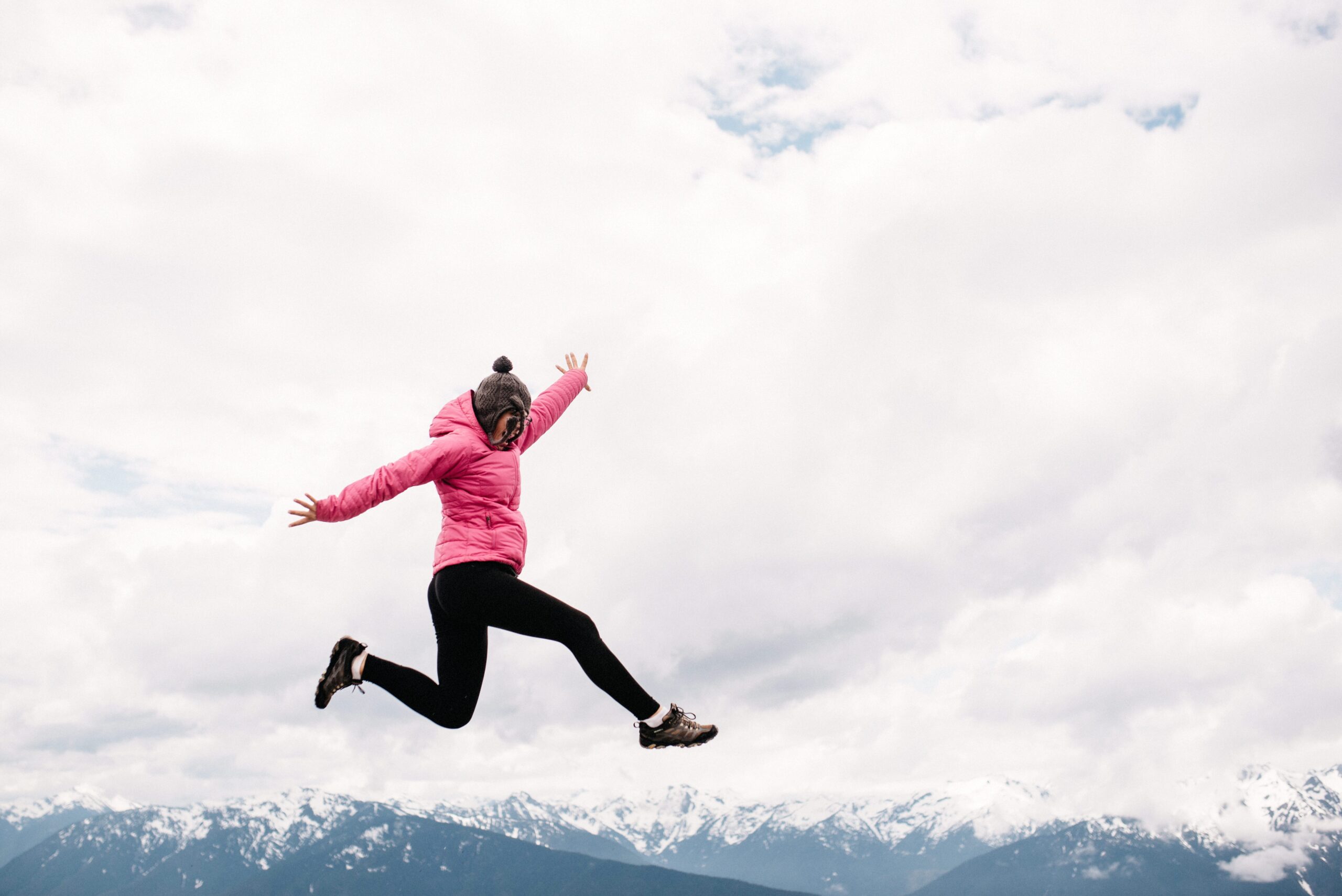 Bianca jumping above the mountain view on the Olympic Peninsula