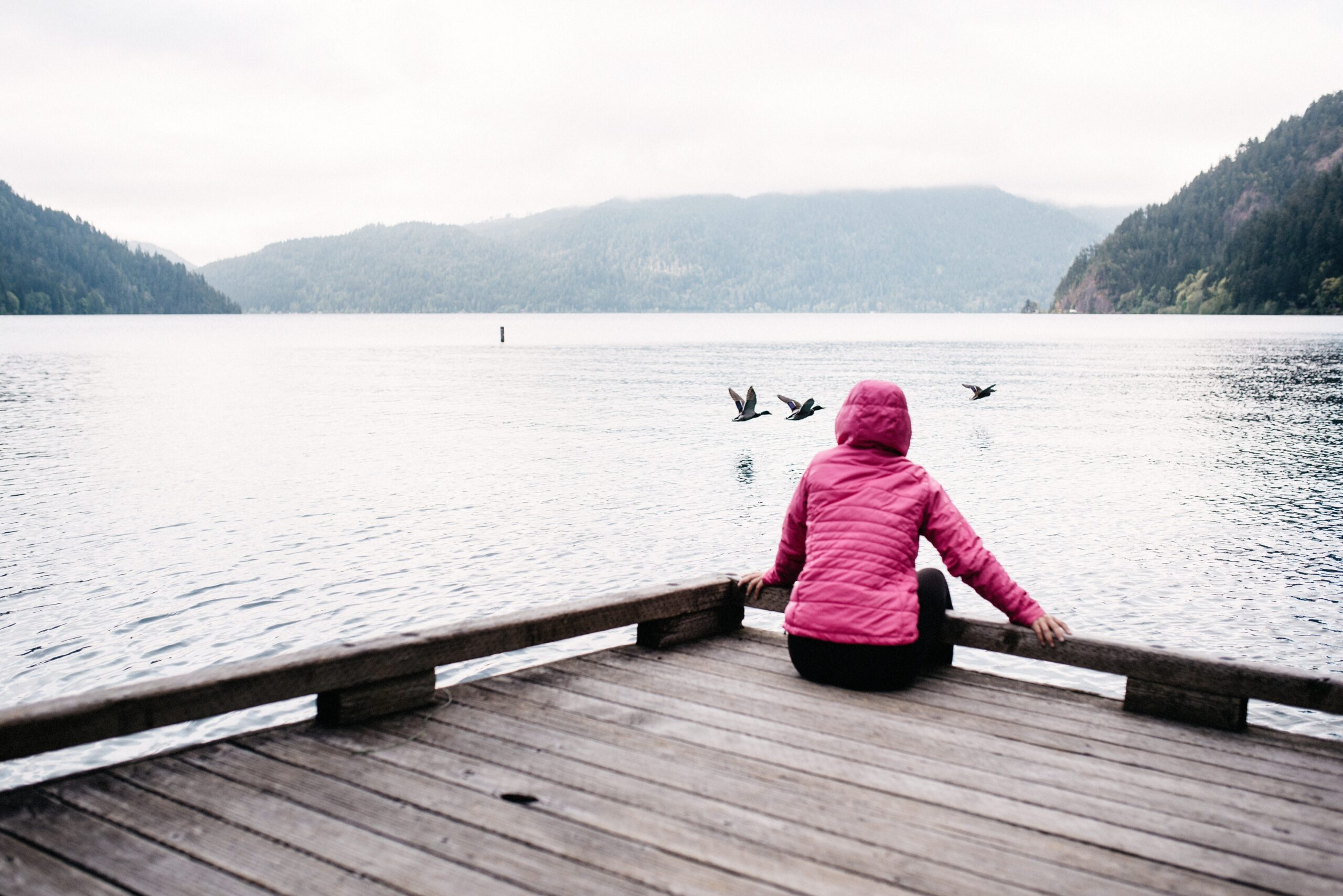Bianca sitting at a quiet lake on the Olympic Peninsula