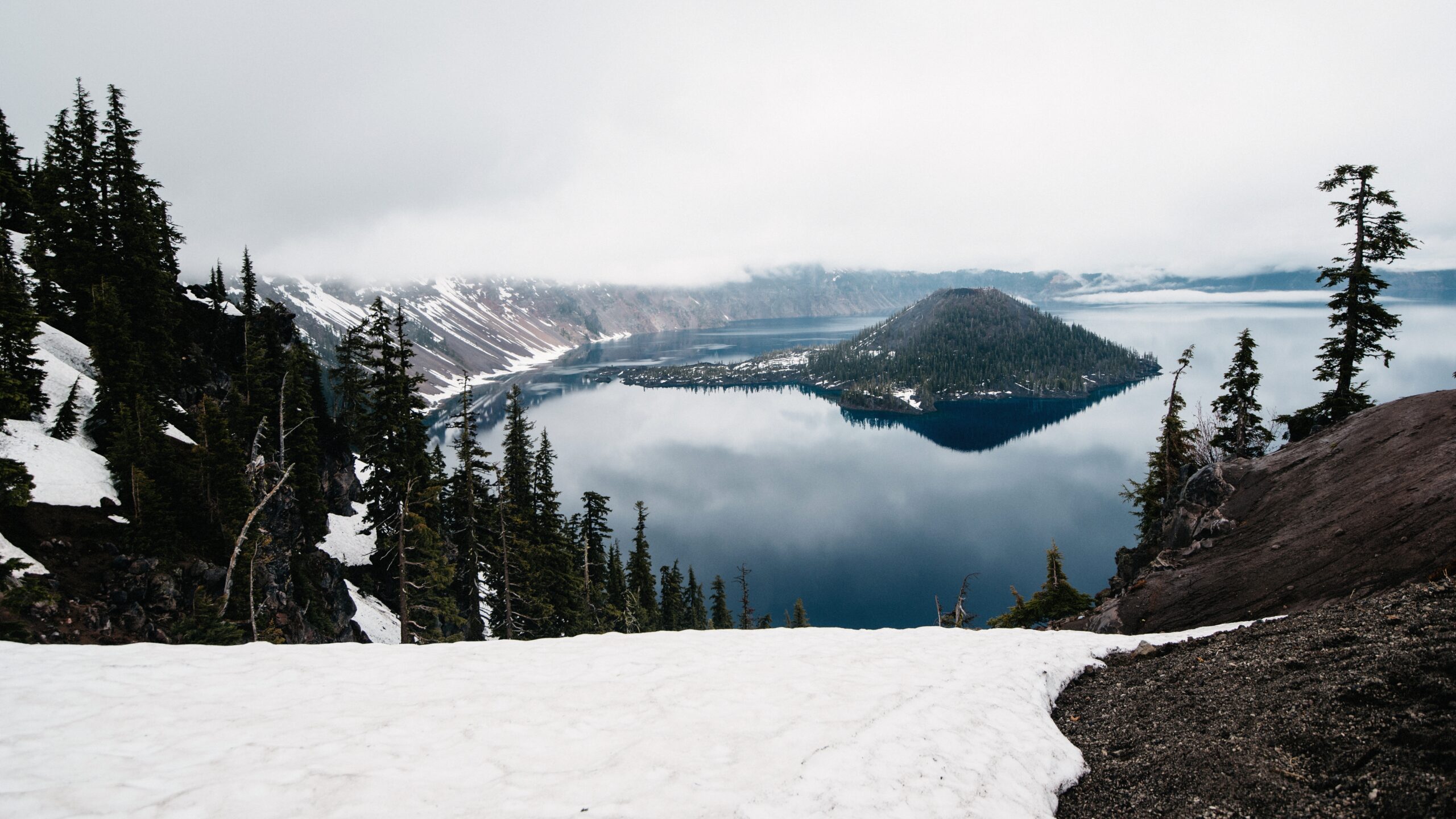Crater Lake ist im Mai von Schnee und tiefen Wolken umgeben