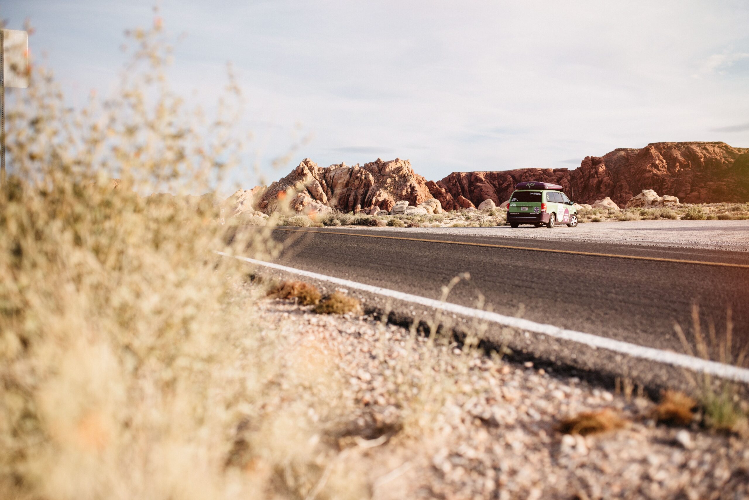 Our green camper van on the road through Valley of Fire