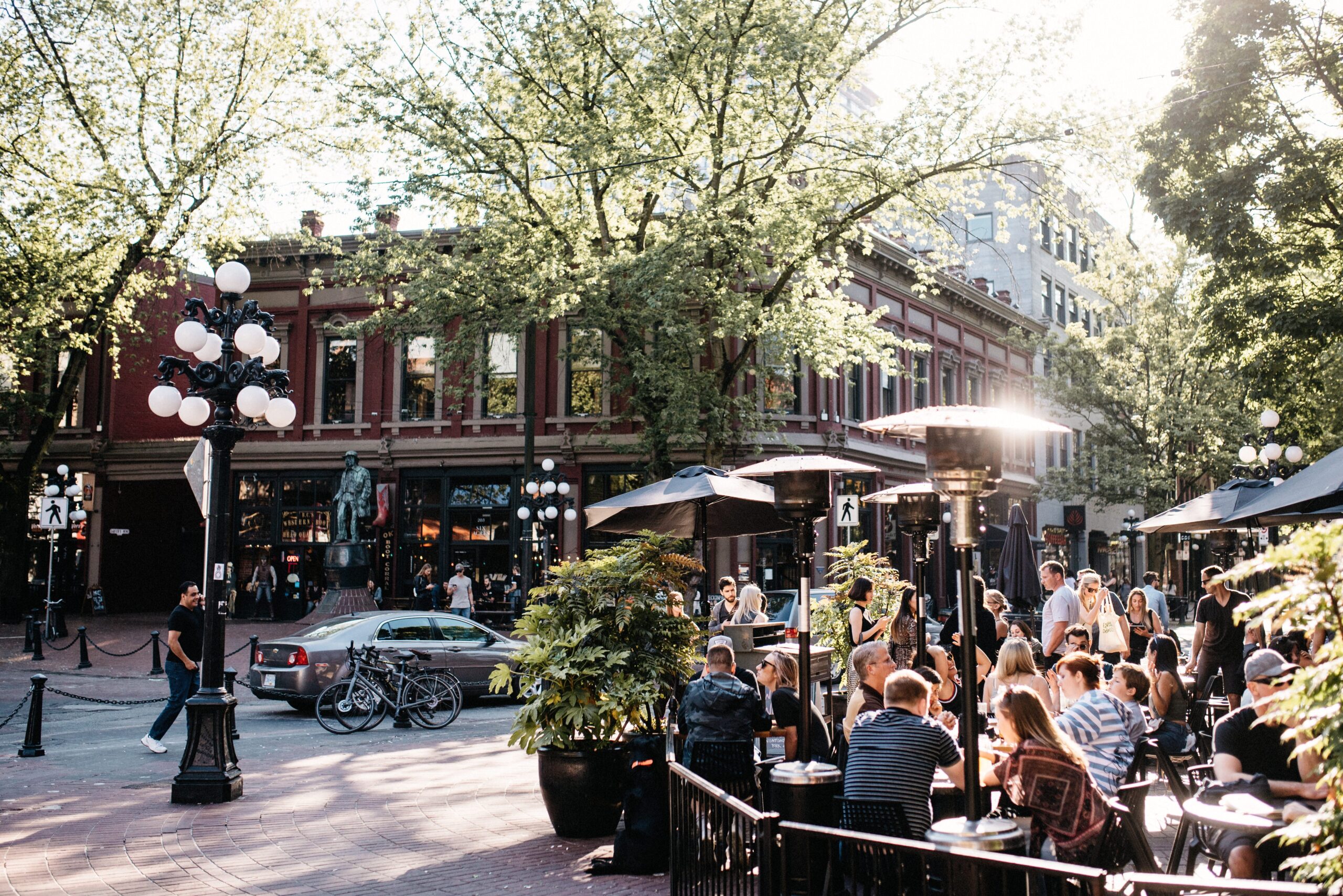 Belebte Restaurantterrassen zwischen den Backsteingebäuden von Gastown