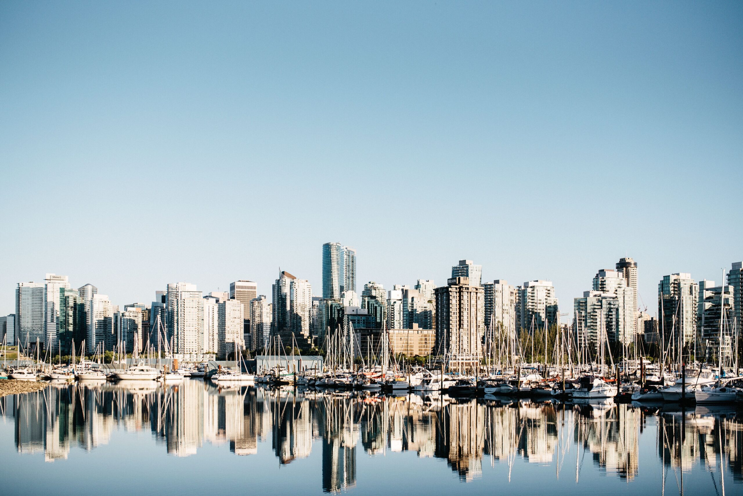 Die Skyline von Vancouver spiegelt sich bei Sonnenuntergang im Hafen