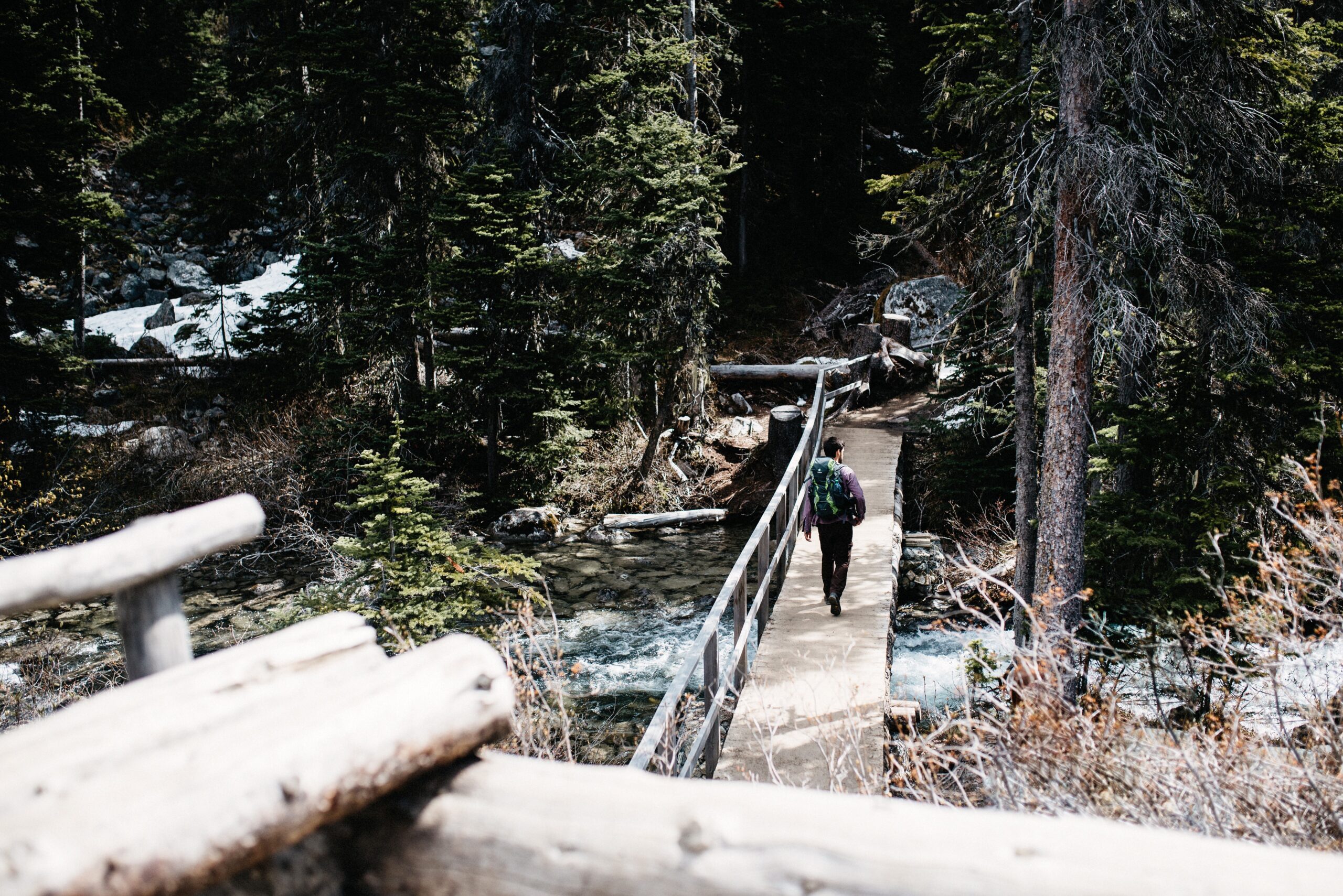 Eine kleine Brücke überquert den verschneiten Weg zum Upper Joffre Lake