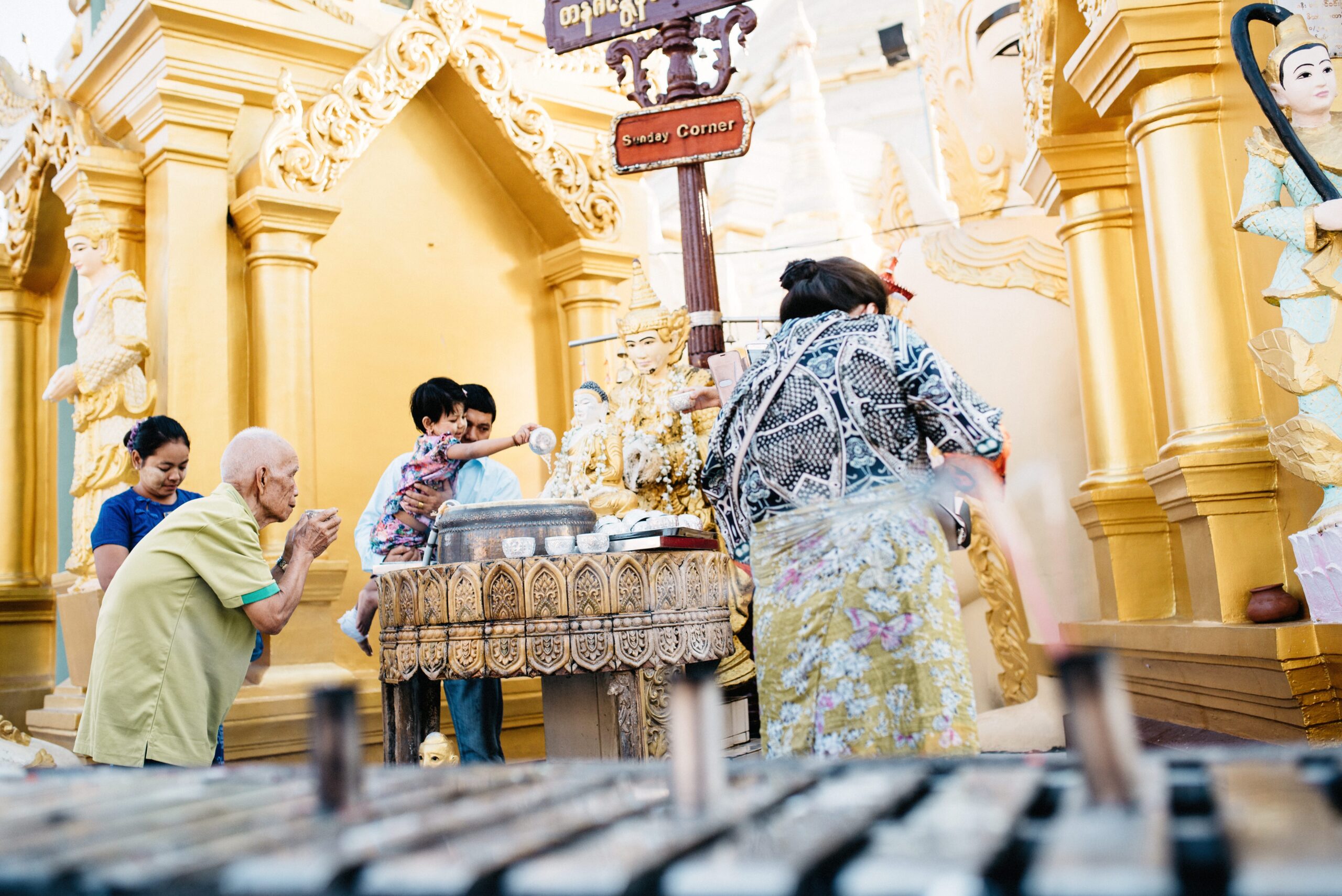 Visitors pouring water over a Buddha statue at Shwedagon Pagoda