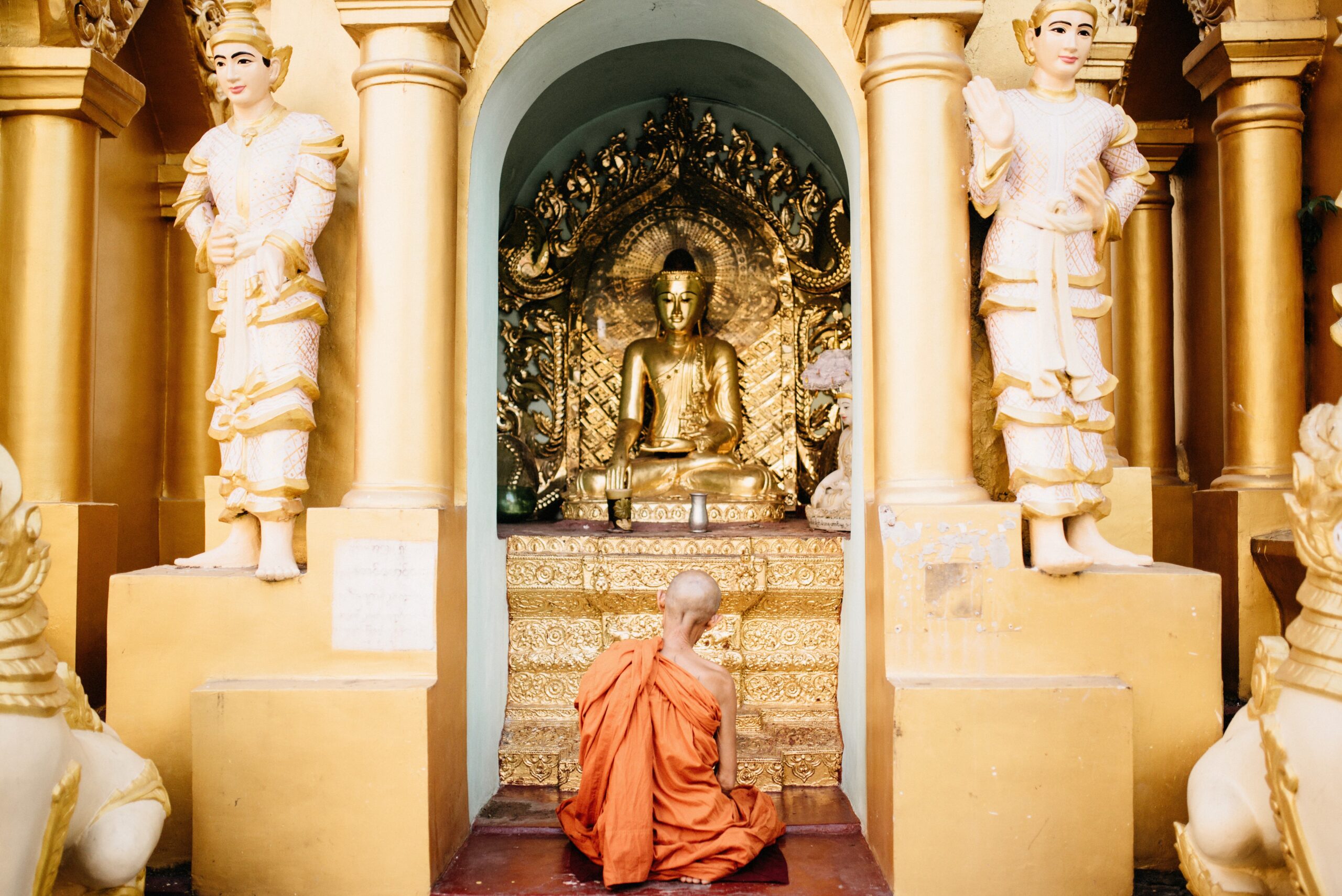 A Buddhist monk sitting inside a shrine at Shwedagon Pagoda