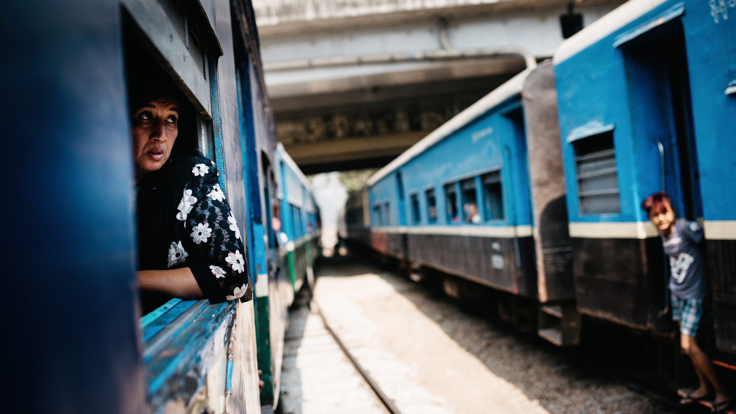 A blue Circular Train carriage passing a station near Yangon